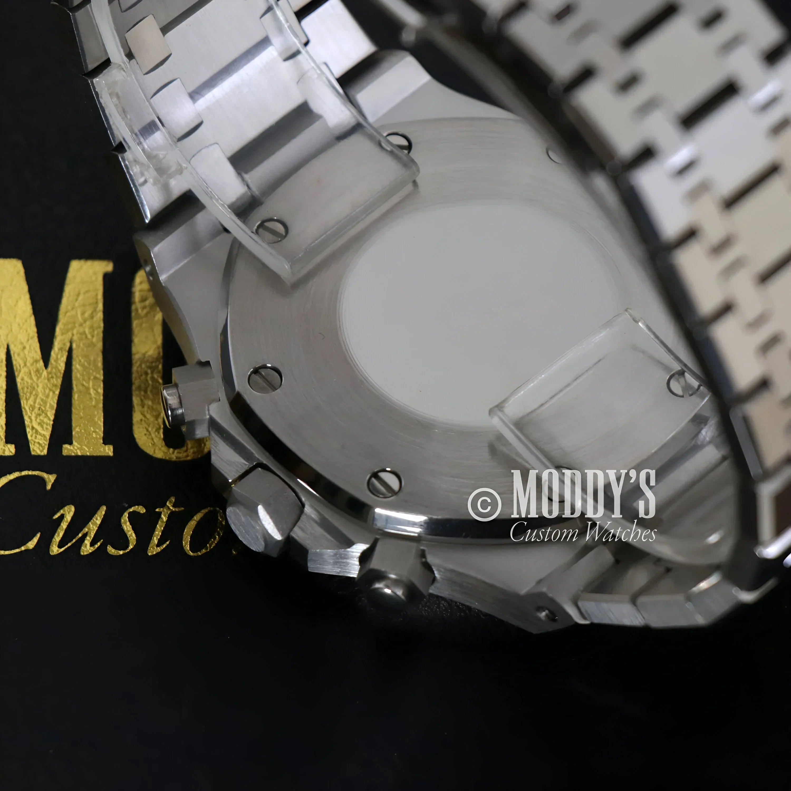 Silver wristwatch with protective film featuring Royal Seikoak and VK63 hybrid movement