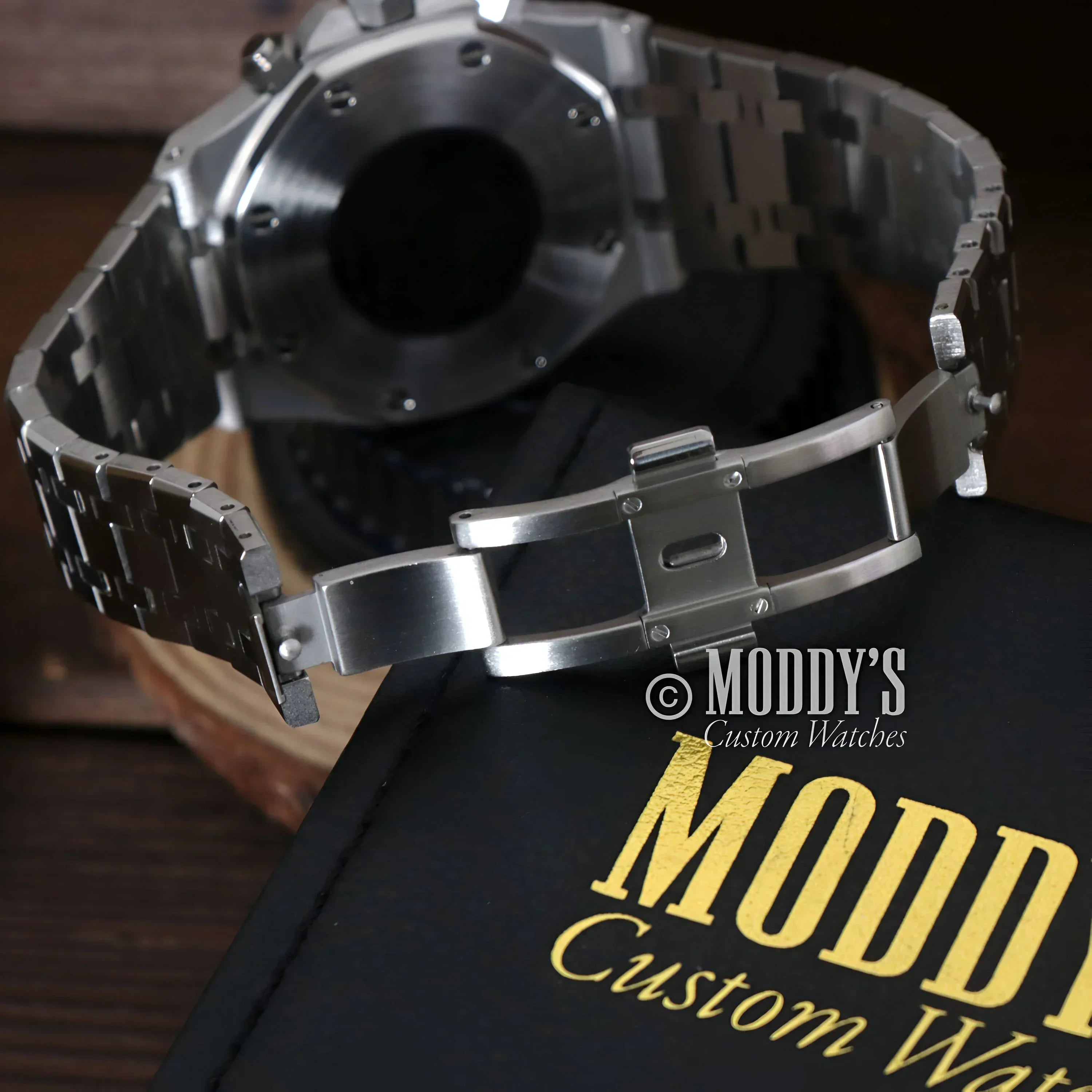 Silver metal wristwatch with open clasp from Royal Seikoak featuring VK63 hybrid movement
