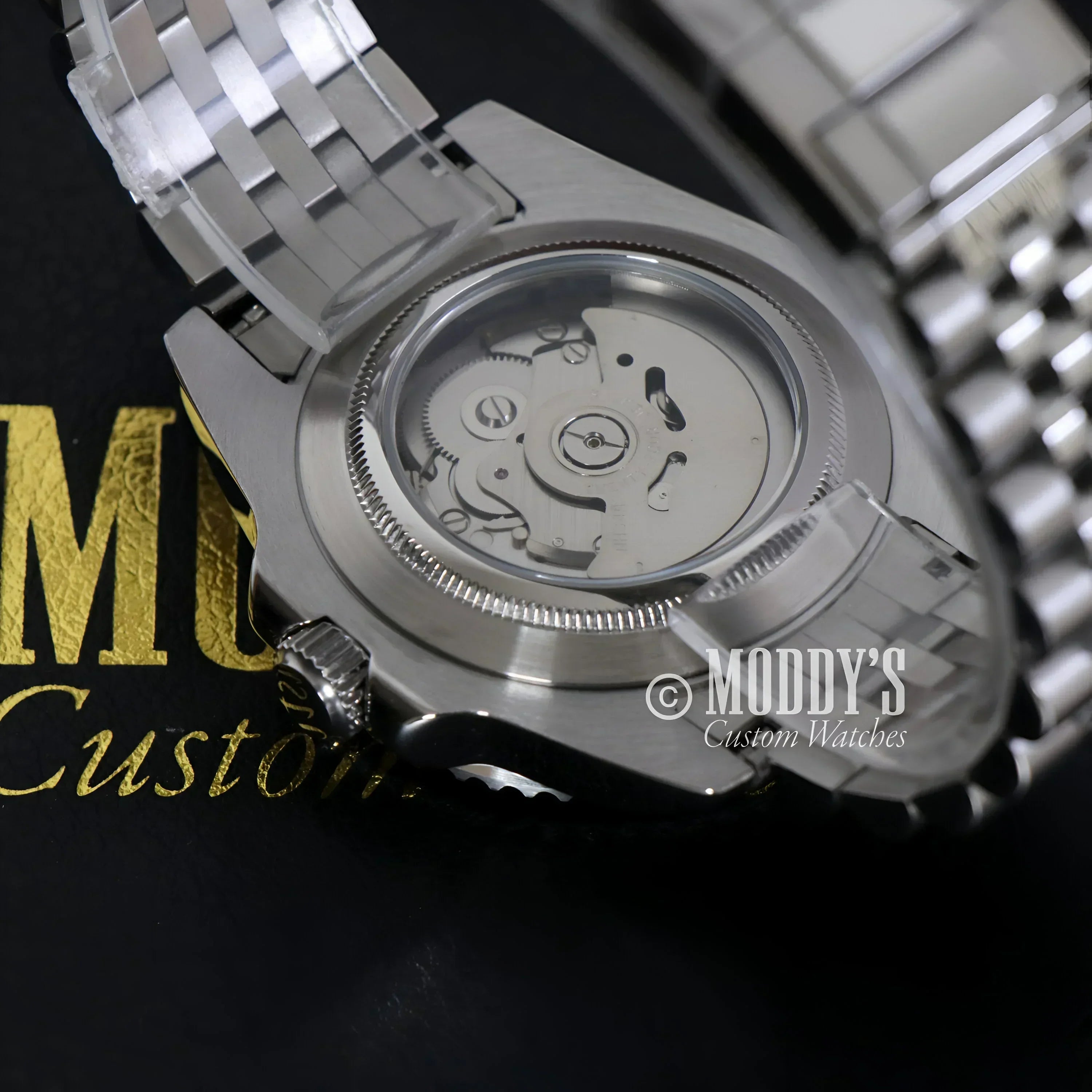 Silver wristwatch with exposed NH34 automatic movement, GMTeiko Bruce Wayne model