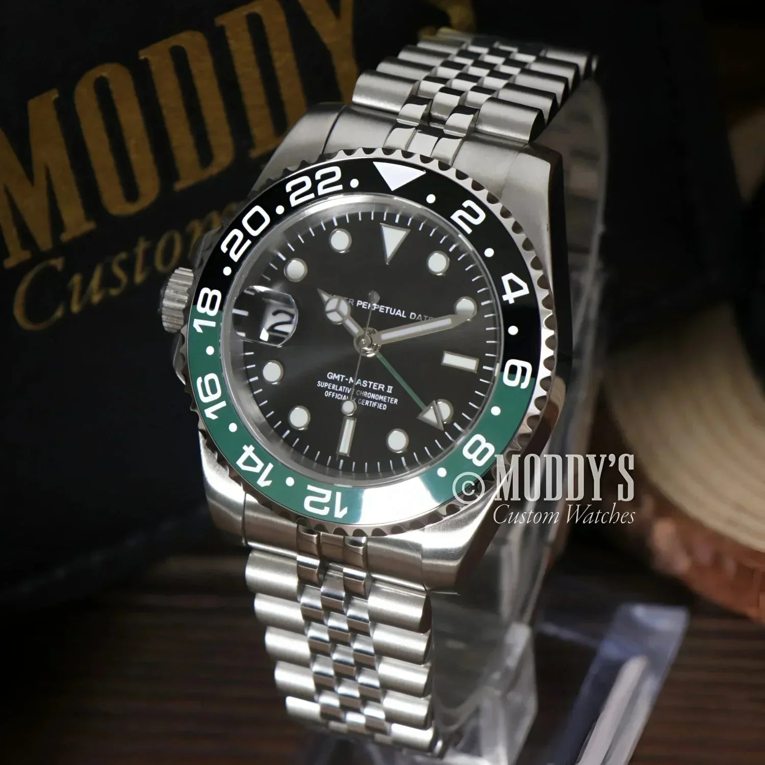 Silver wristwatch GMTeiko Sprite with black and green bezel, featuring Seiko NH34 movement
