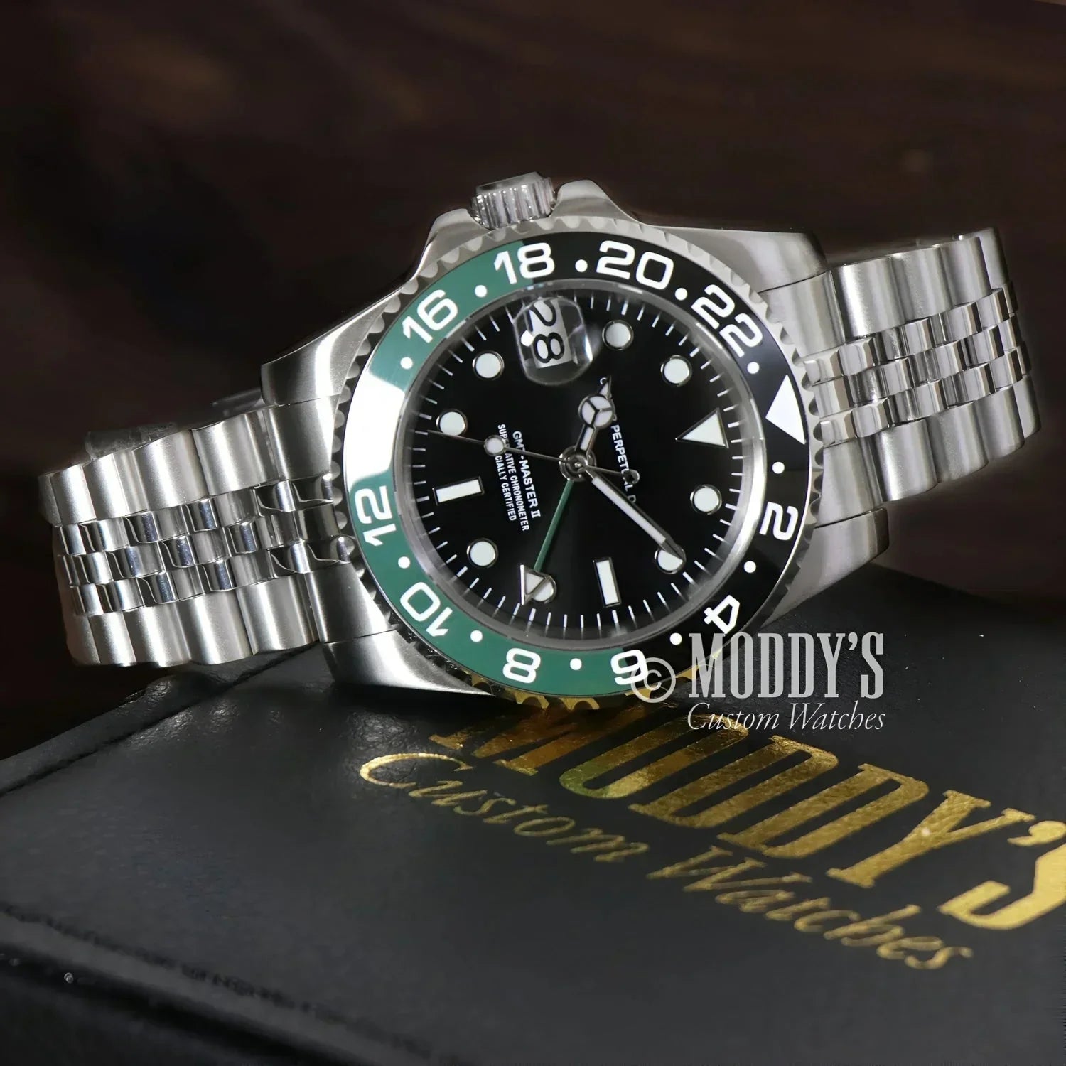 Silver GMTeiko Sprite wristwatch with green and black bezel, featuring Seiko NH34 movement