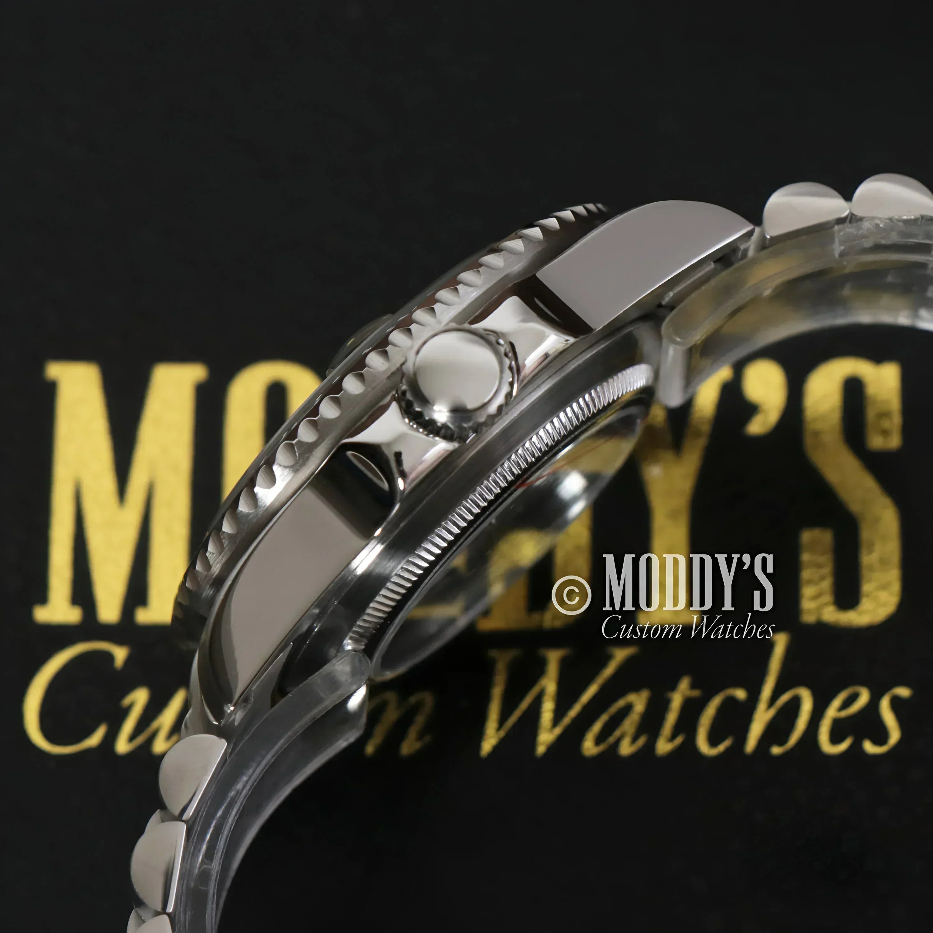 Silver wristwatch with serrated bezel from GMTeiko Sprite featuring Seiko NH34 automatic movement