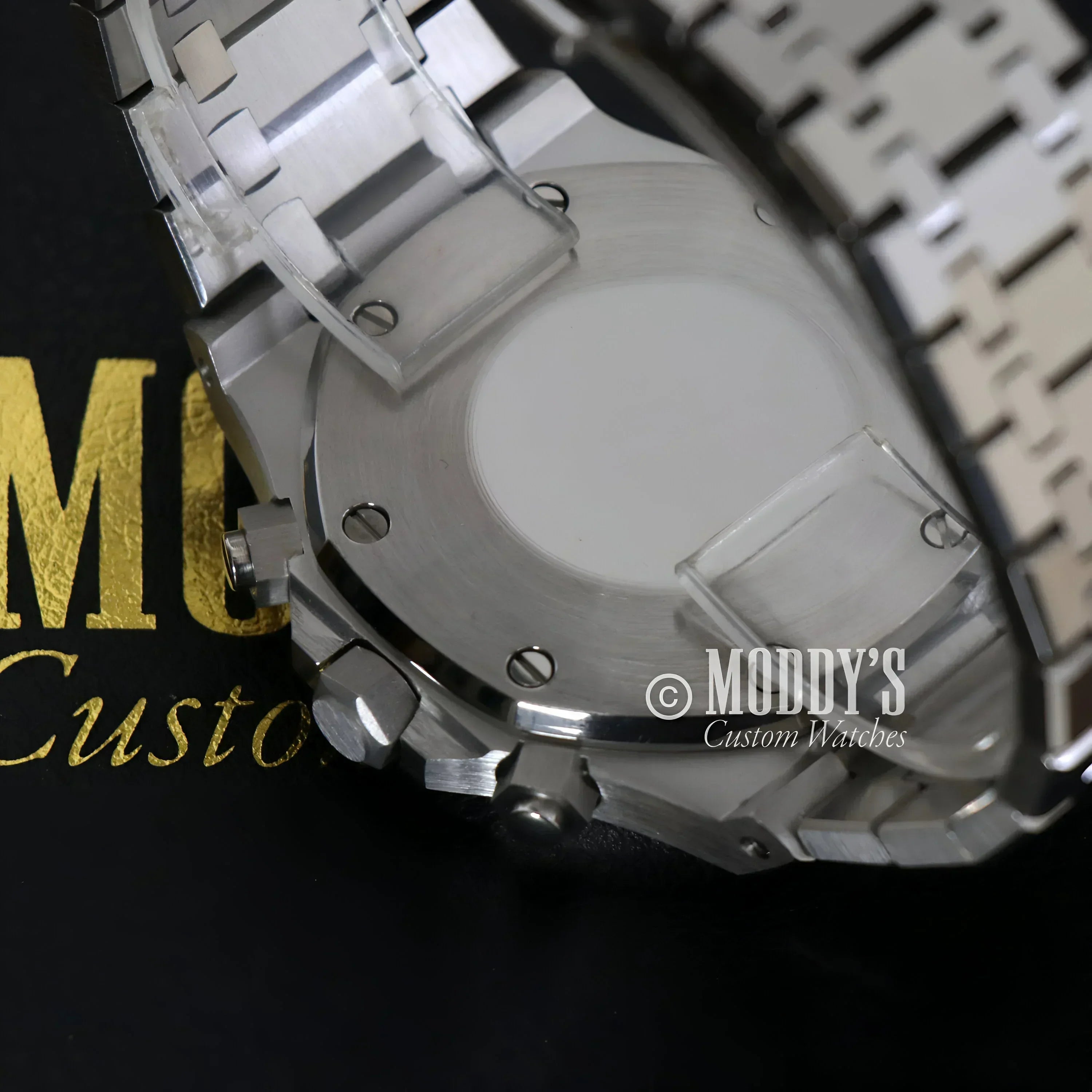 Silver wristwatch with protective film featuring Royal Seikoak and VK63 hybrid movement