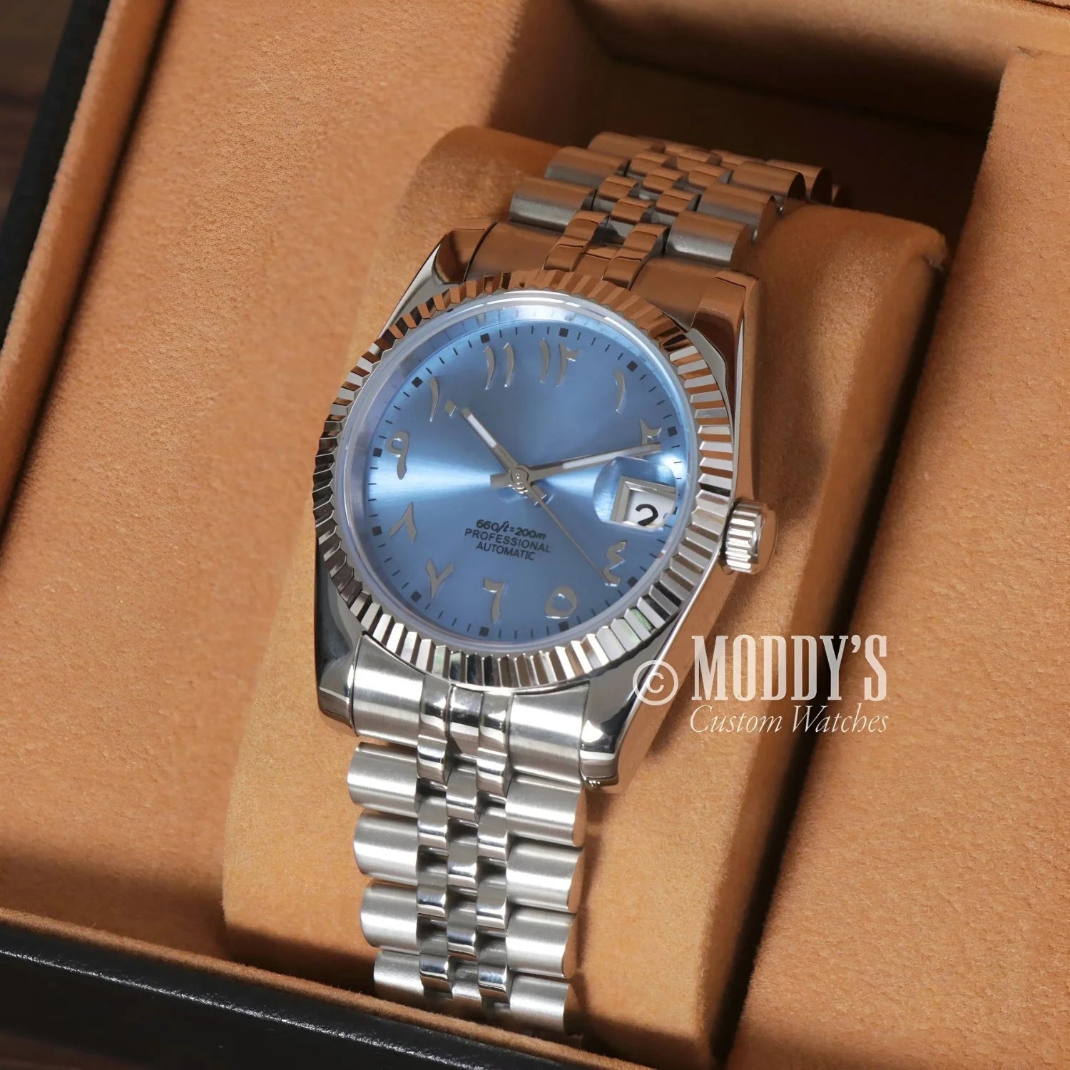 Silver wristwatch with light blue face from Seikojust Ice Blue Arabic, featuring Seiko NH35 automatic