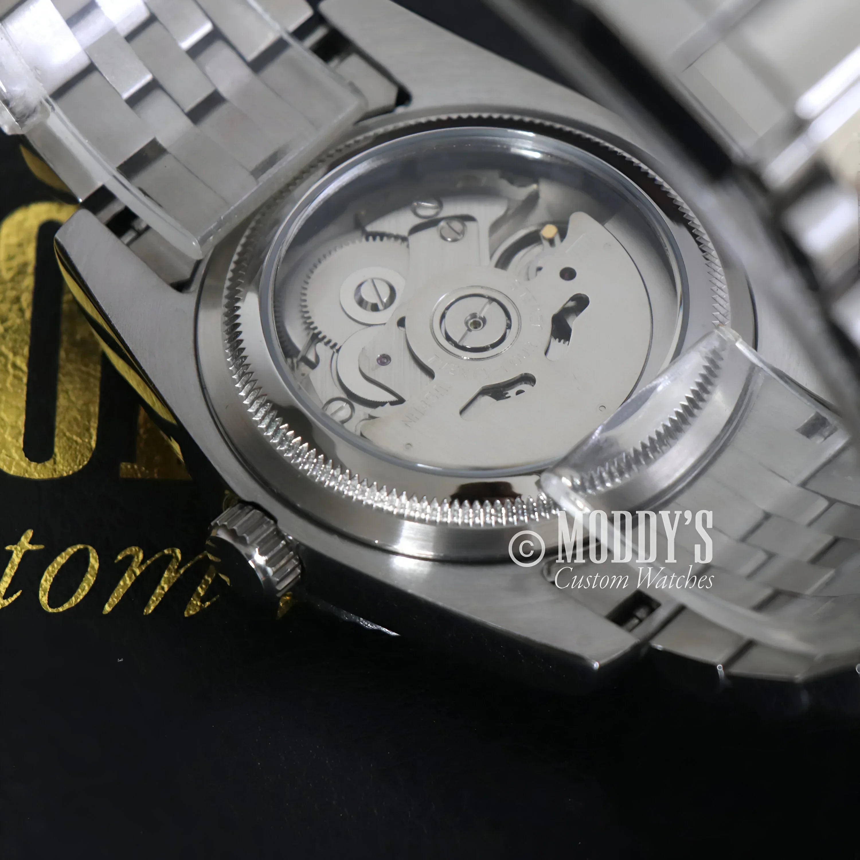 Silver wristwatch with exposed movement featuring Seiko NH35 automatic and 904L stainless steel