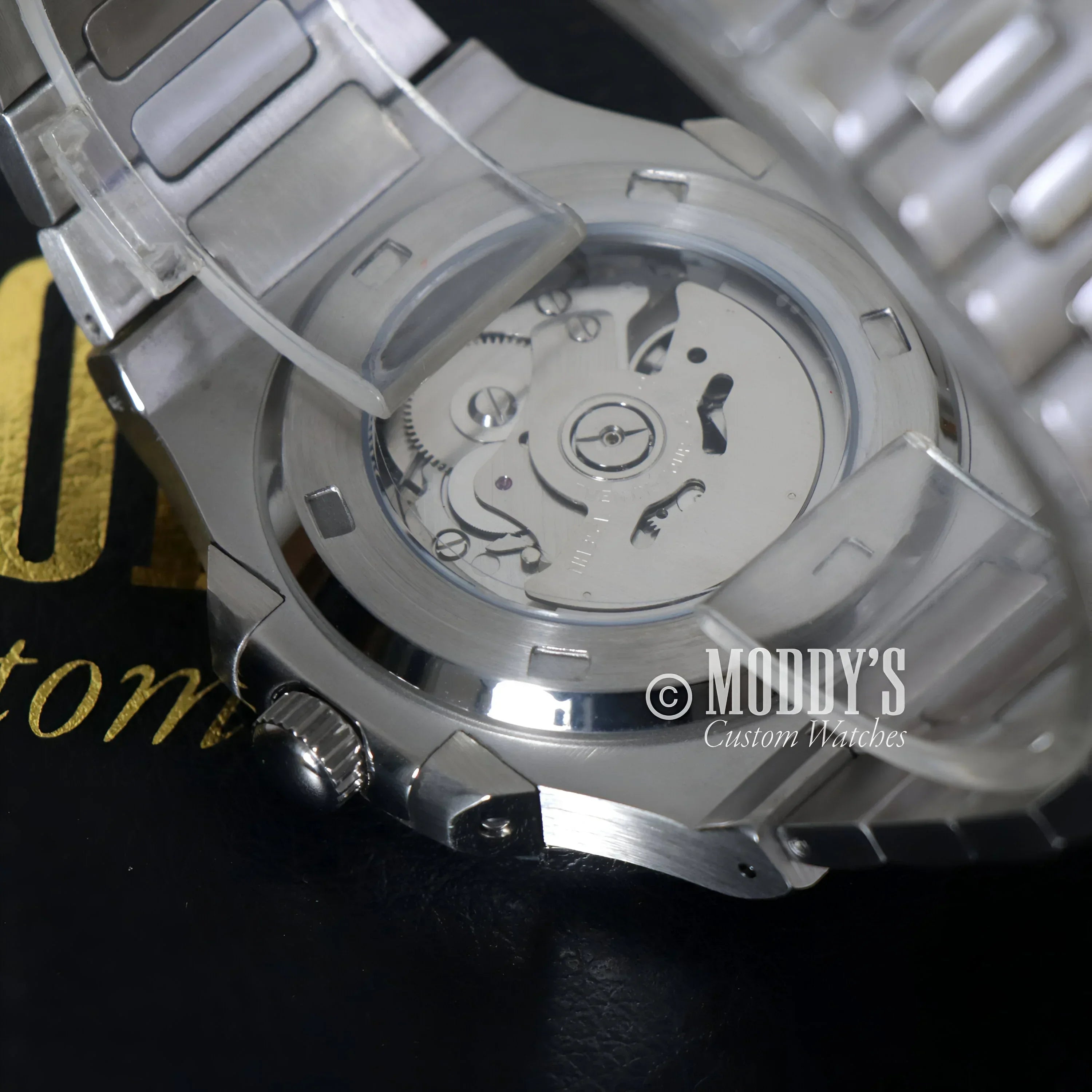 Silver wristwatch with exposed movement featuring NH35 automatic movement and 904L stainless steel