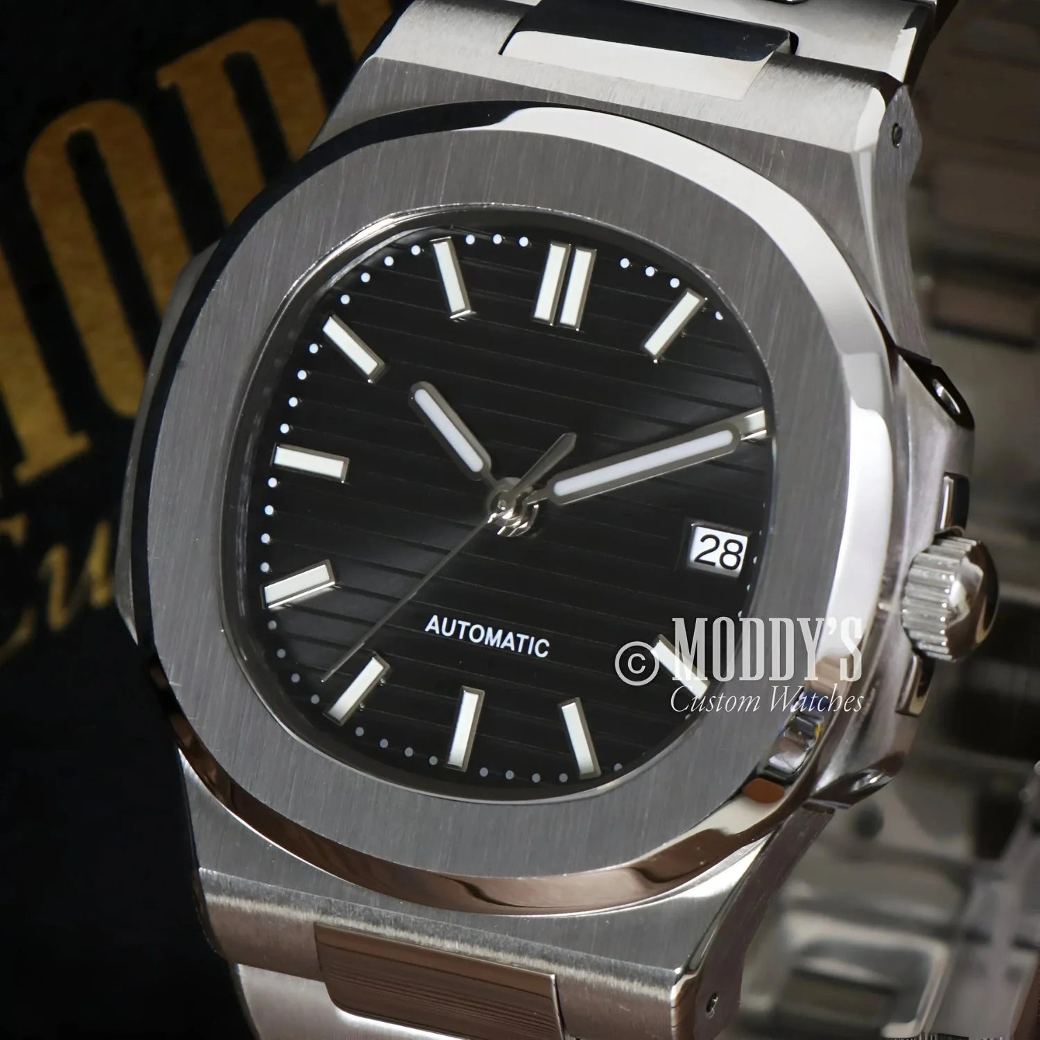 Silver wristwatch with black face featuring NH35 automatic movement and 904L stainless steel