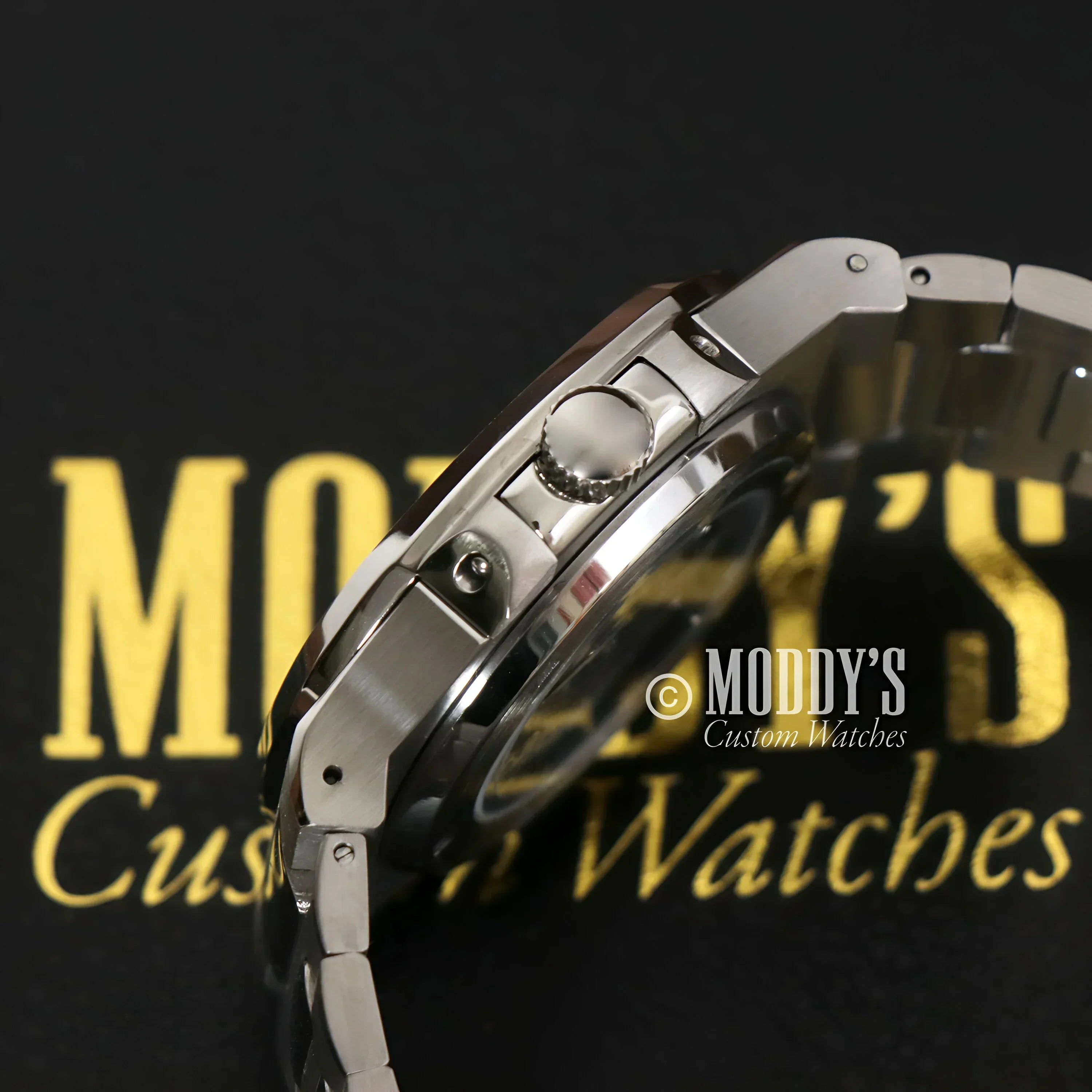 Silver wristwatch with metal band featuring NH38 automatic movement and 904L stainless steel