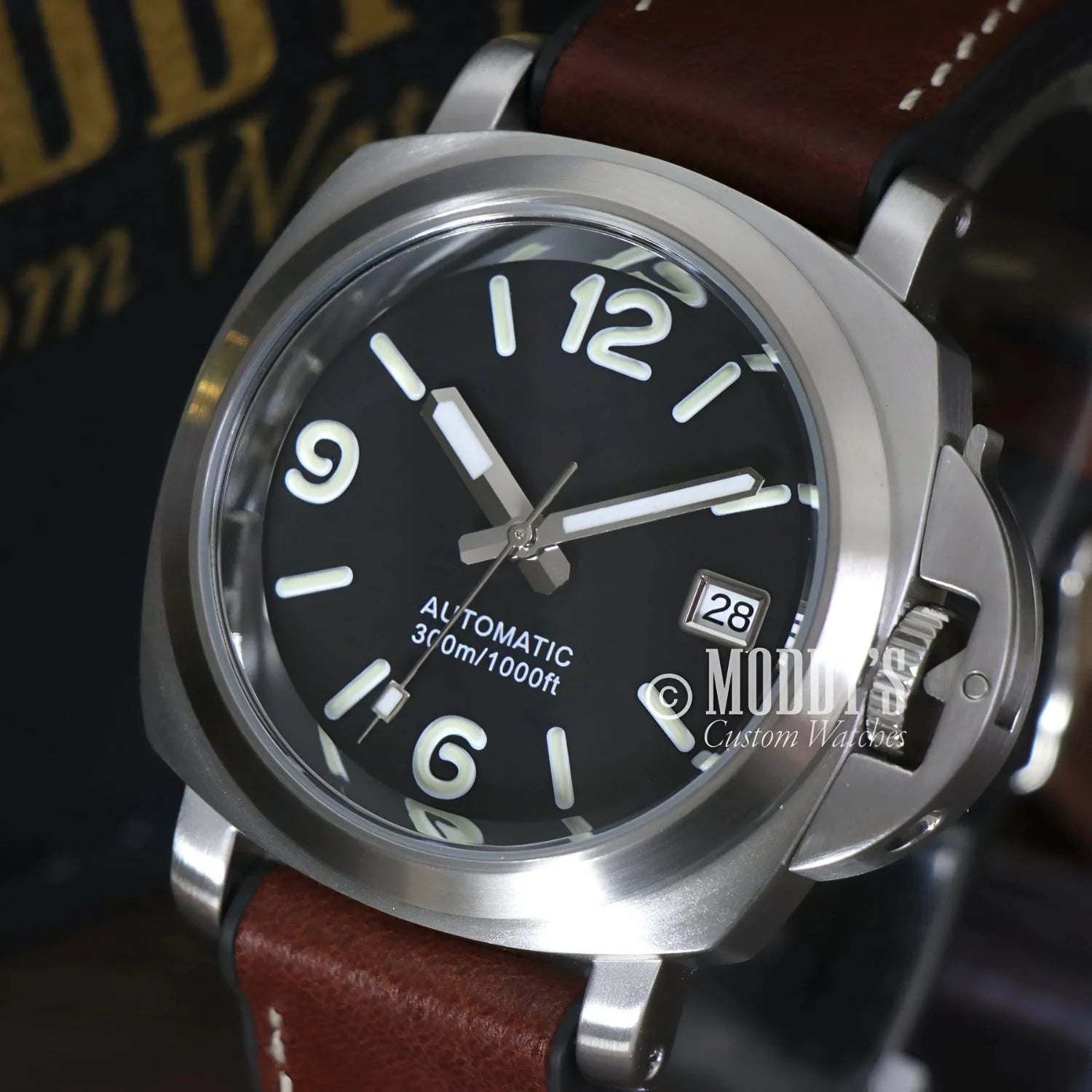 Silver wristwatch with brown leather band featuring Seiko NH35 automatic movement