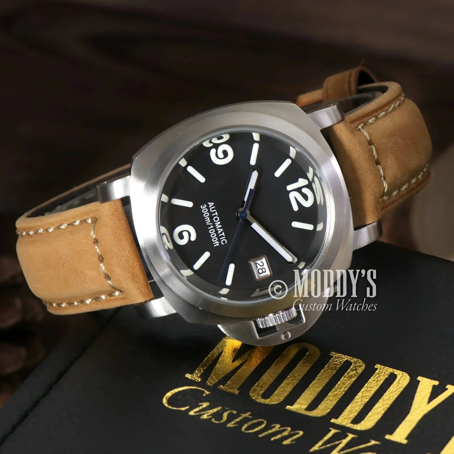Silver wristwatch with tan leather band featuring Seiko NH35 automatic movement
