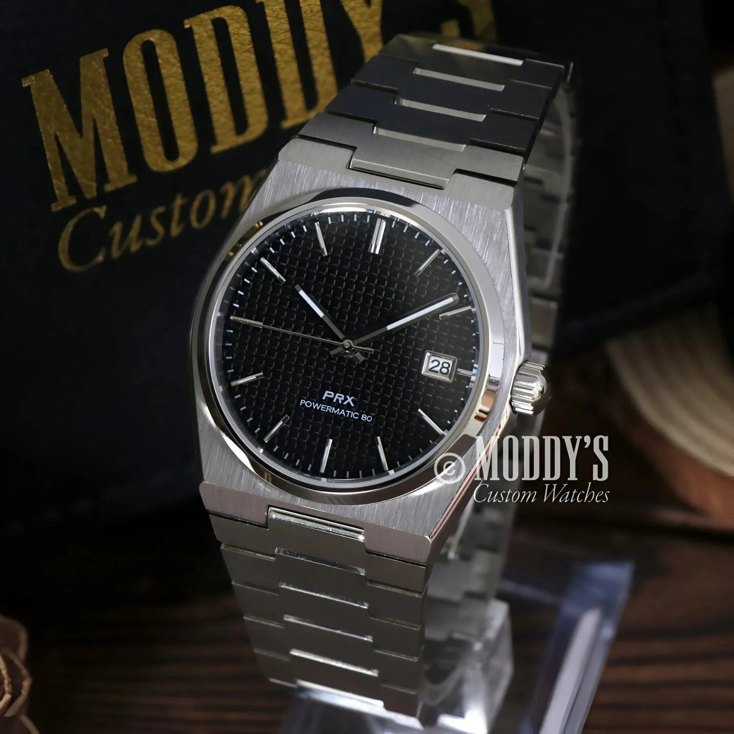 Silver wristwatch with black textured dial featuring Seiko NH35 automatic movement