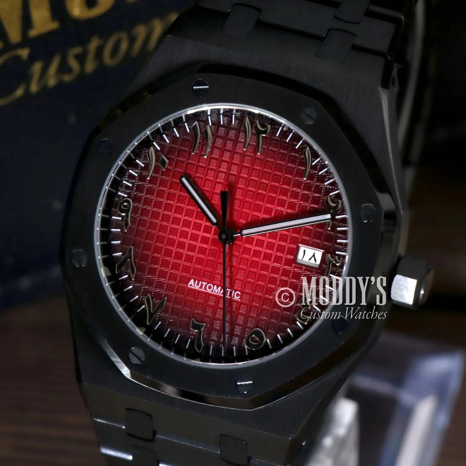 Black wristwatch with red patterned face and Arabic numerals, featuring NH35 automatic movement