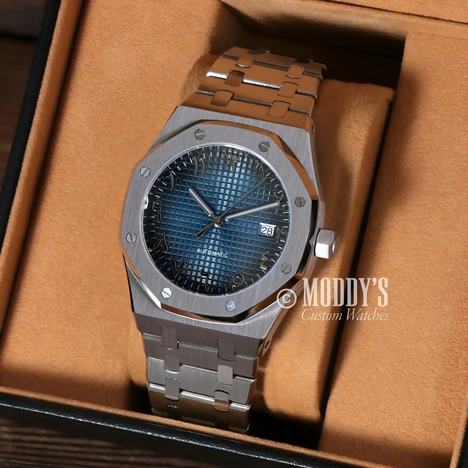 Silver wristwatch with blue patterned face from Royal Seikoak featuring Arabic Blue design