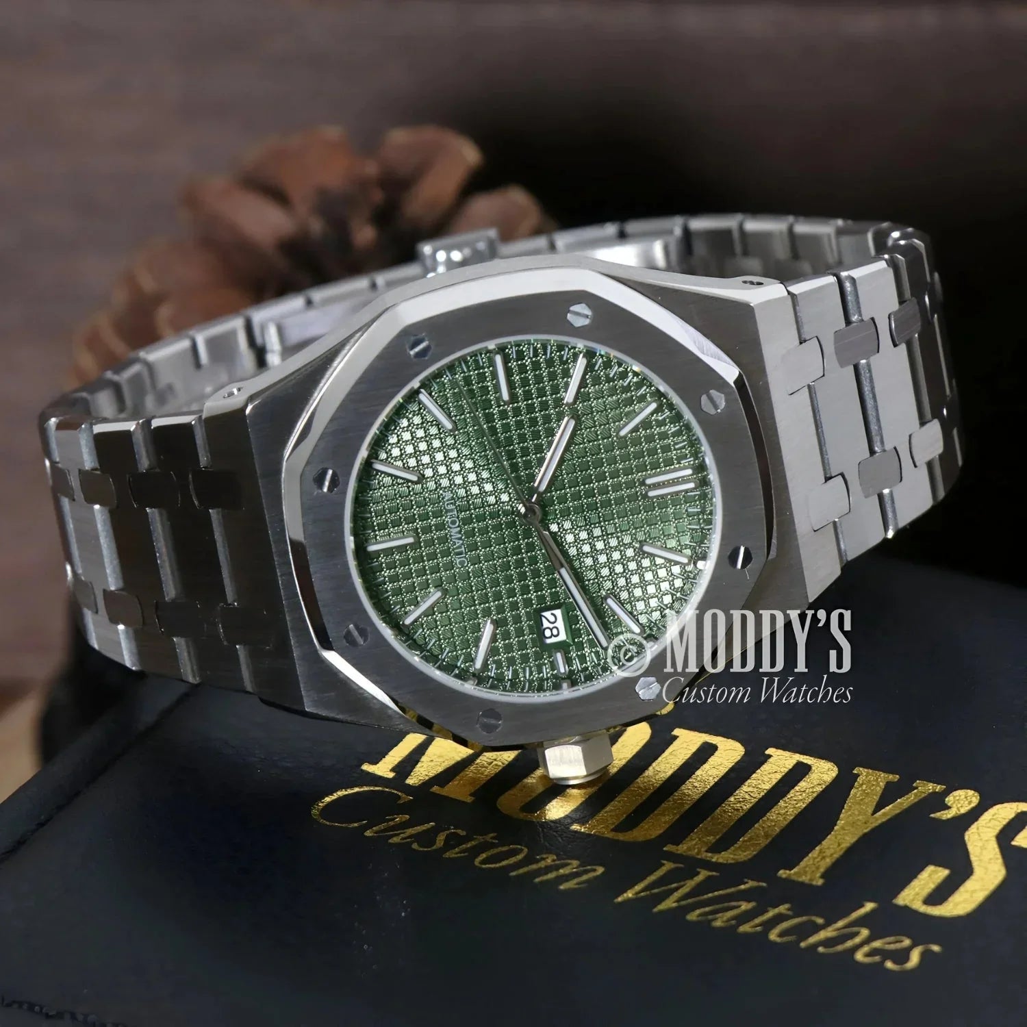 Silver wristwatch with green face from Royal Seikoak in olive green style