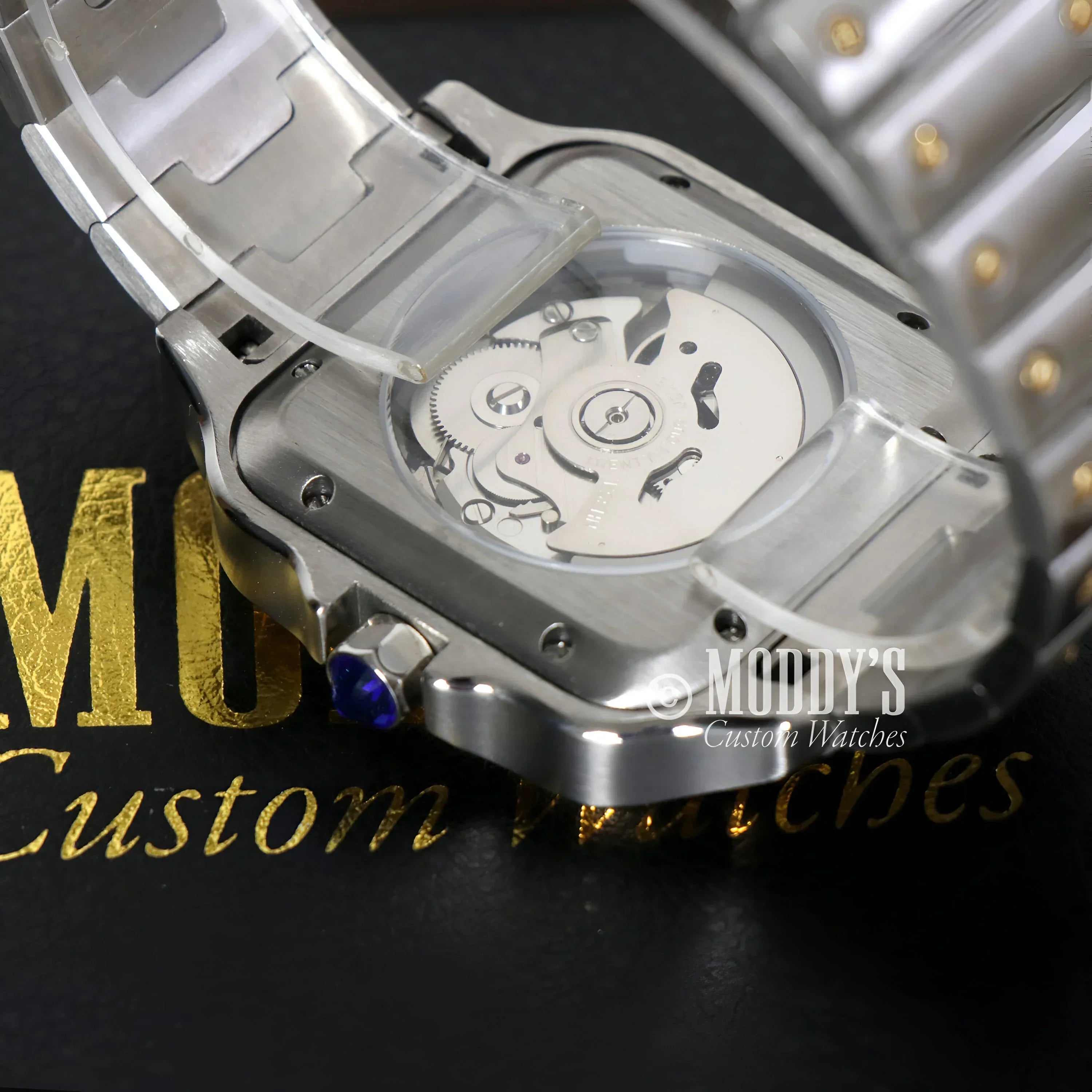 Silver wristwatch with exposed movement featuring Seiko NH35 automatic technology