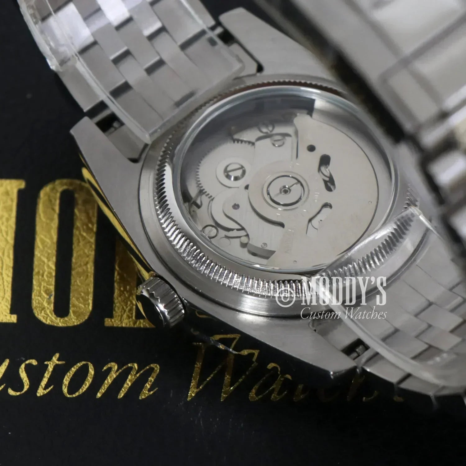 Silver Seikojust Arabic Cosmos wristwatch featuring a visible Seiko NH35 automatic movement