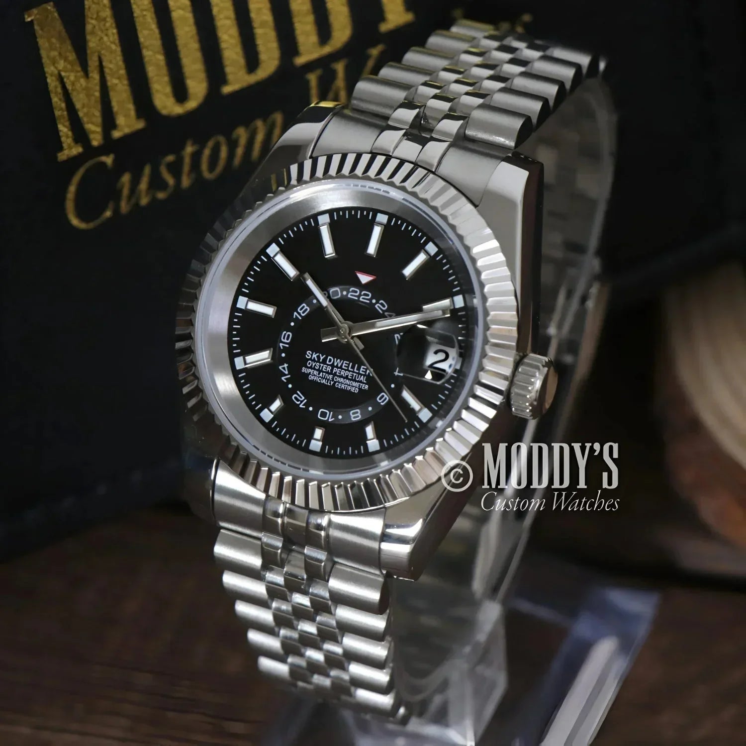 Silver wristwatch with black face, Seikojust Sky Dweller, features Seiko NH35 movement