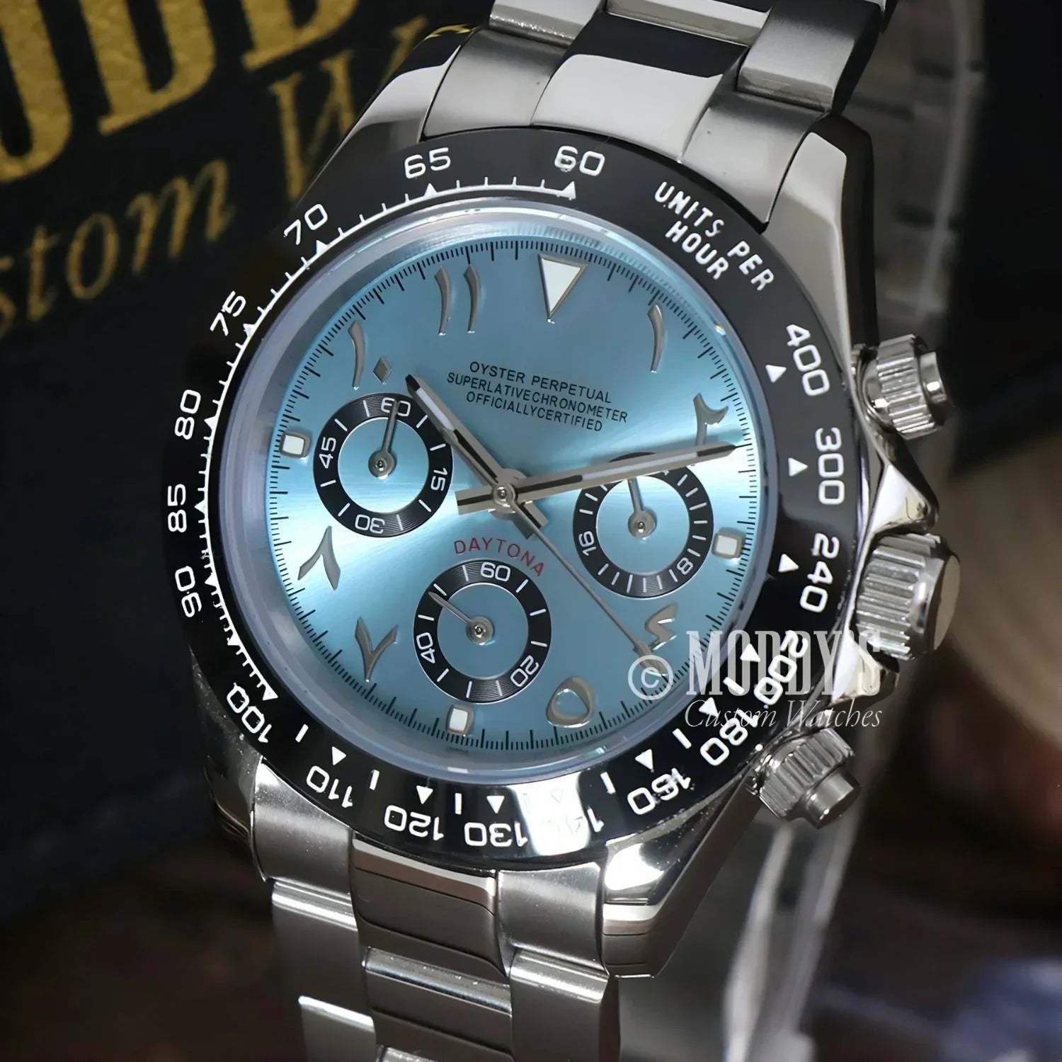 Silver Rolex Daytona watch with Arabic numerals and Arabic ice blue face