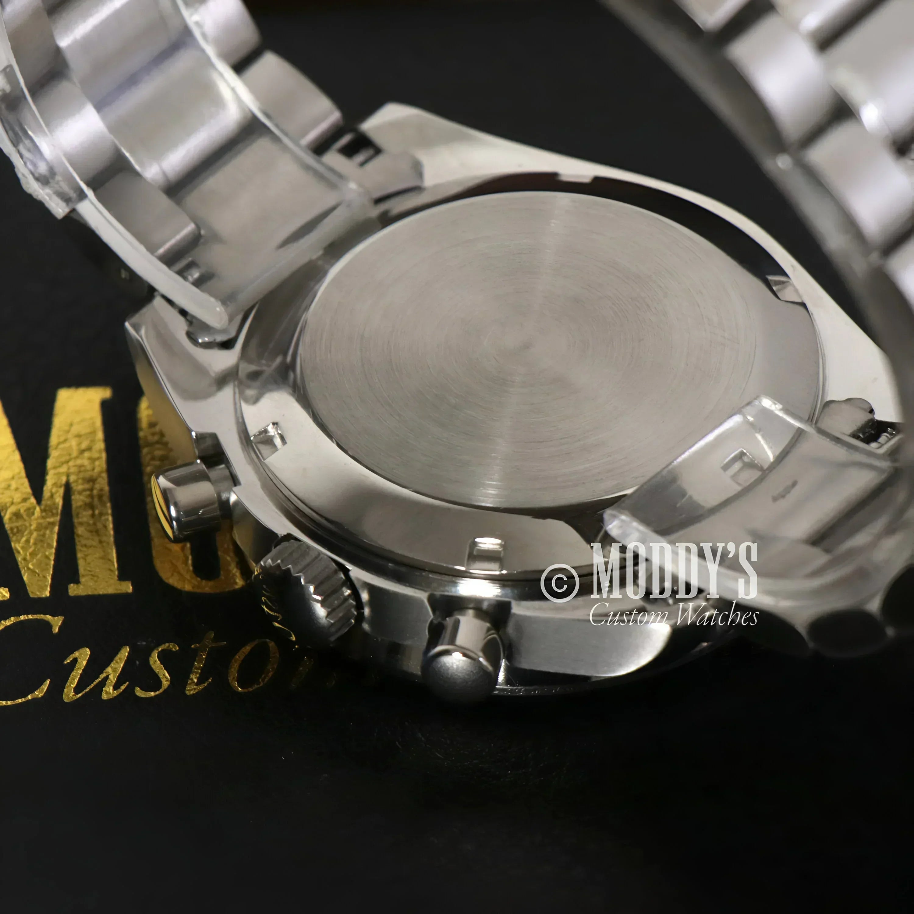 Silver wristwatch back of Speedseiko Black featuring Seiko VK63 hybrid movement
