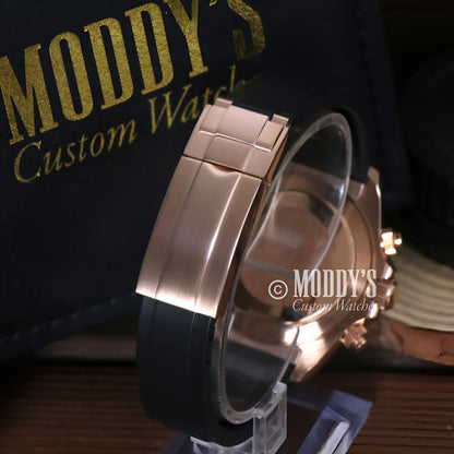 Seiko VK63 hybrid rose gold watch with black rubber strap on clear stand