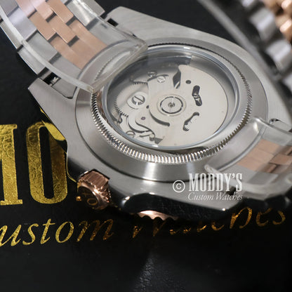 GMTeiko Rootbeer stainless steel watch with rose gold accents, Seiko NH34 automatic movement, and transparent back