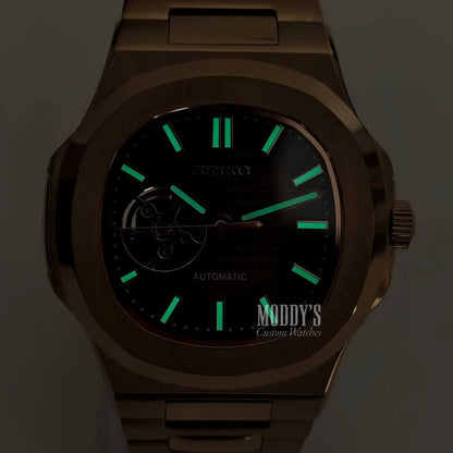 Gold-tone Patek Philippe Nautilus watch with black dial and green luminous hands