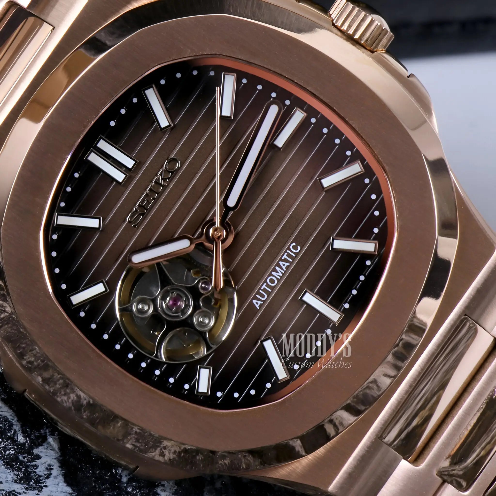 Rose gold Patek Philippe Nautilus watch with brown dial and silver accents