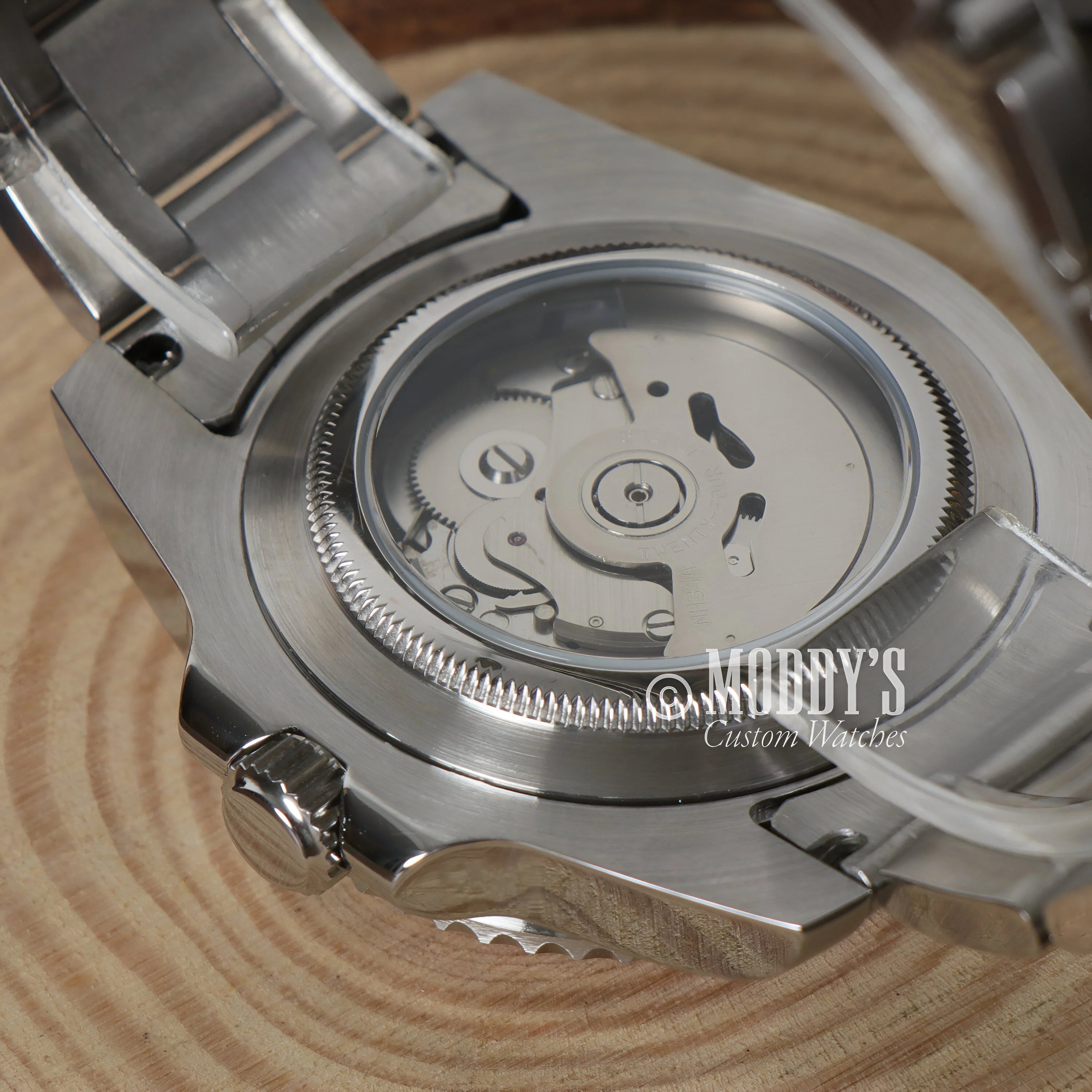 Watch movement visible through the transparent case of the GMTeiko Coke GMT