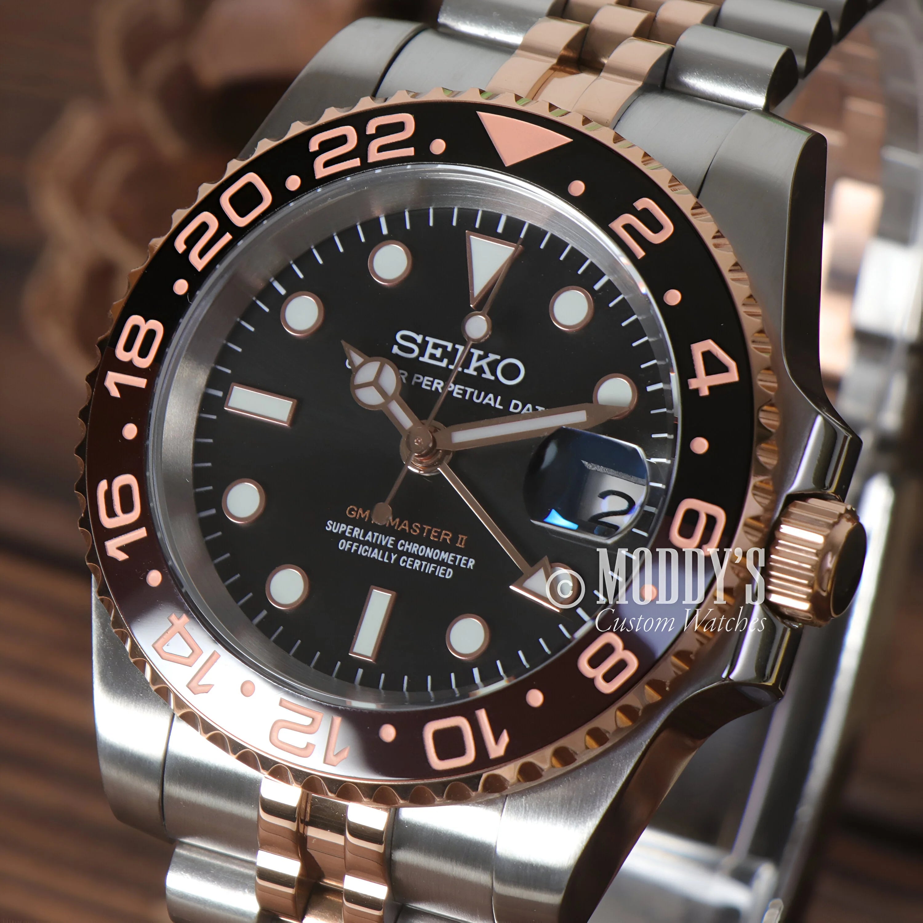 Seiko Mod GMT Rootbeer wristwatch with black dial and two-tone bracelet