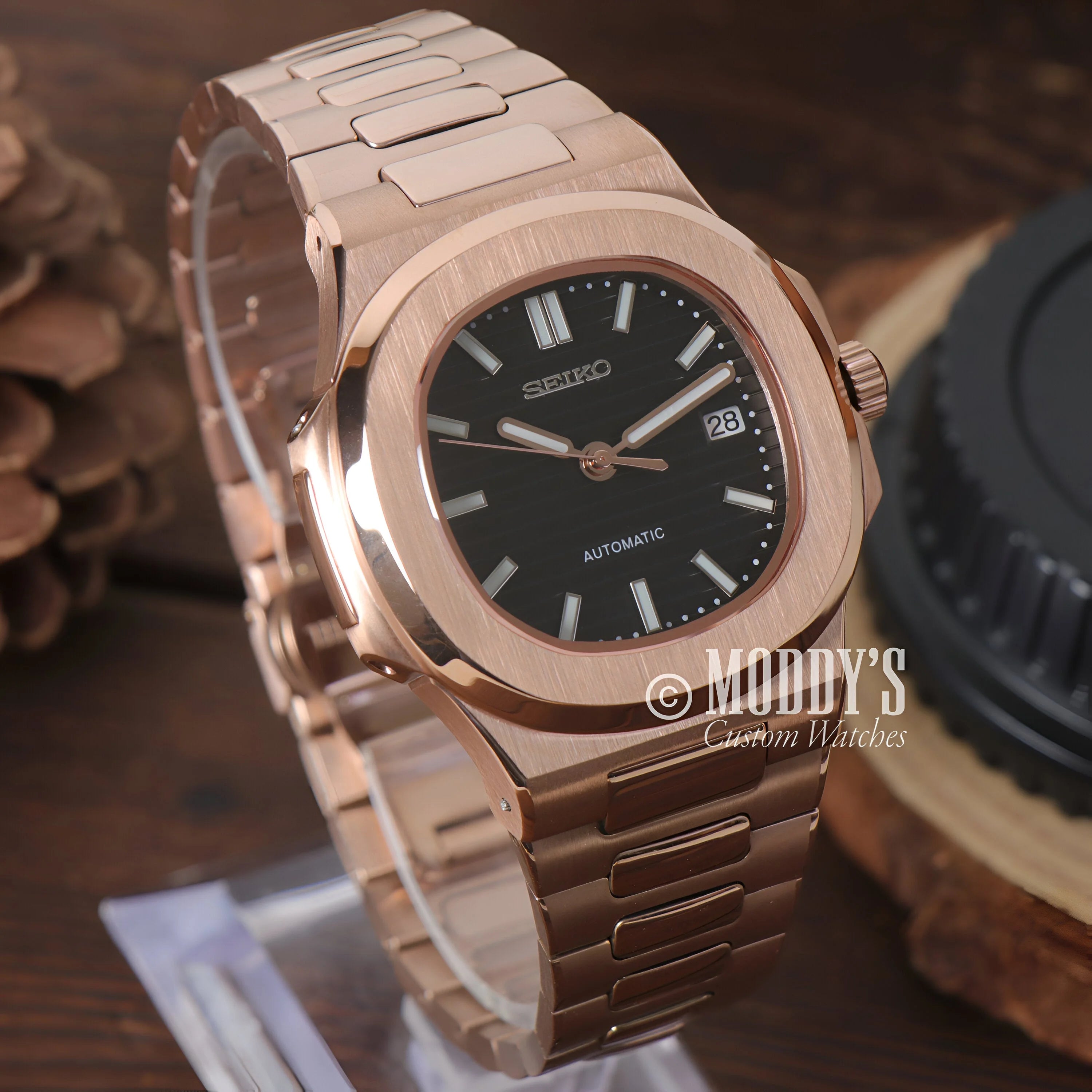 Rose Gold Patek Philippe Nautilus watch with black dial and metal bracelet from Nautiko