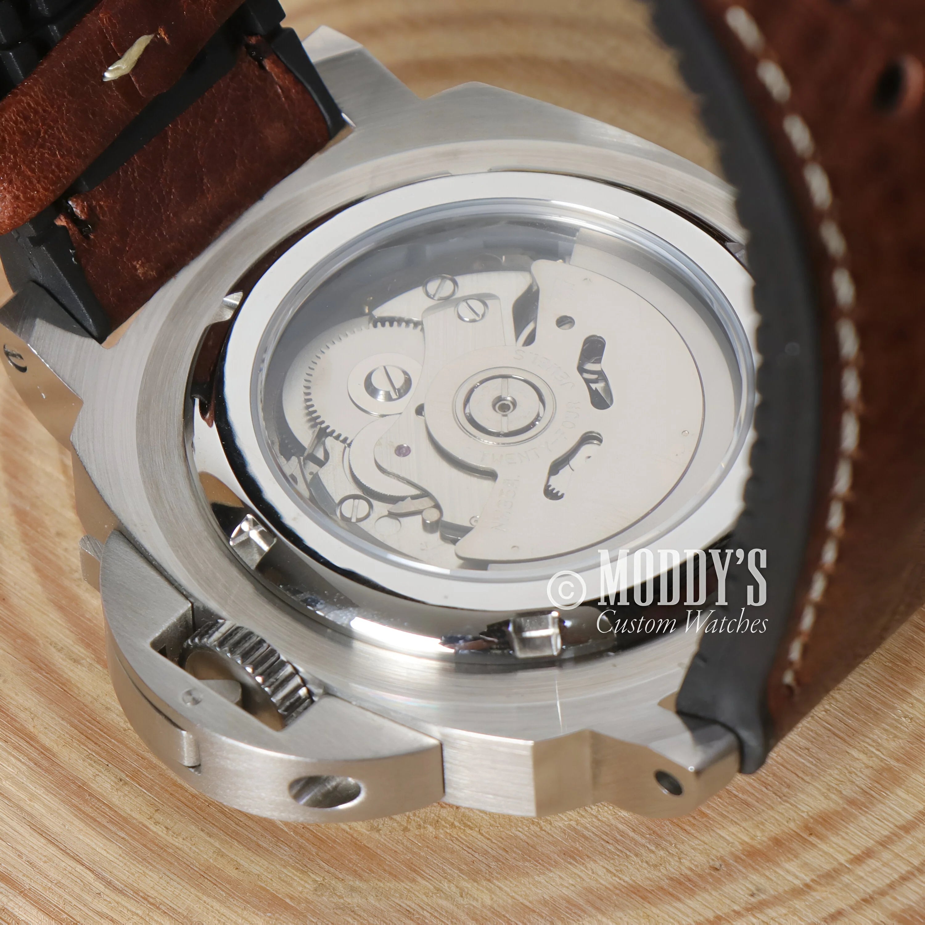 Mechanical watch movement through transparent case back of Paneiko Brown Seiko NH35 Automatic