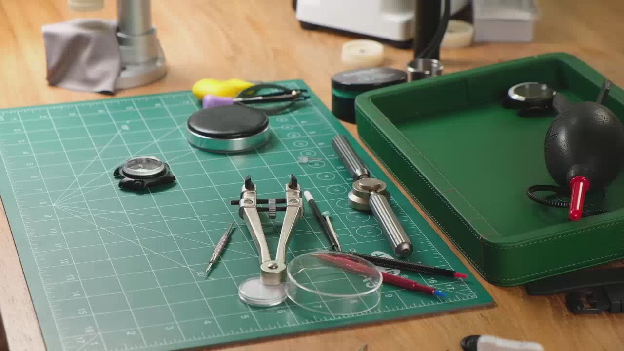 Load video: This slideshow captures the meticulous hand assembly of a custom Seiko mod watch. It opens with close-up shots of the watchmaker placing the dial onto the movement, followed by the precise installation of the hands using specialized tools. The case is then prepared, and the movement is carefully secured inside. The bezel and crystal are gently pressed into position, and finally, the strap is attached. The finished timepiece is presented under bright light, showcasing its refined craftsmanship and unique custom design.