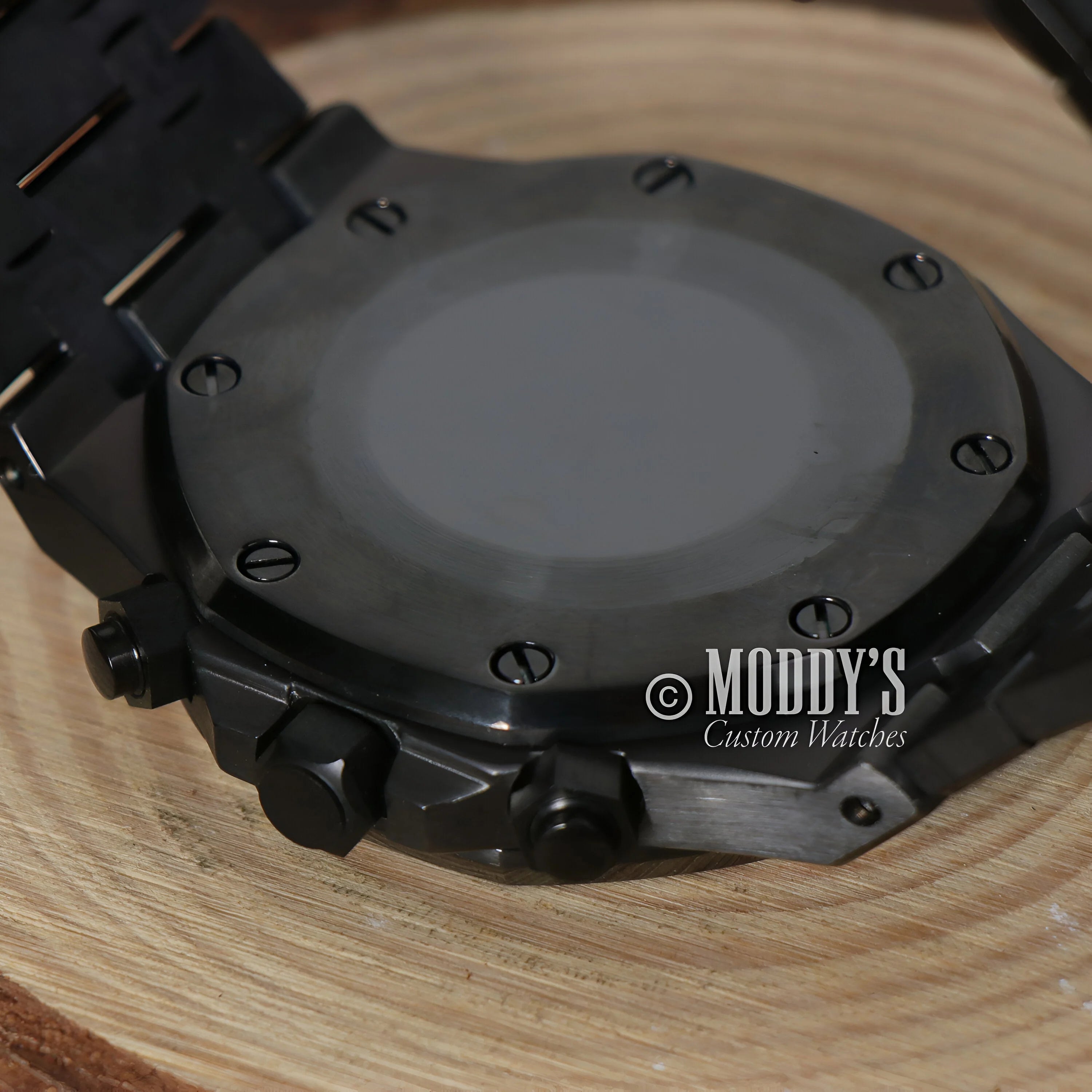 Black octagonal watch case of Royal Seikoak Chrono Triple Black with visible screws and buttons