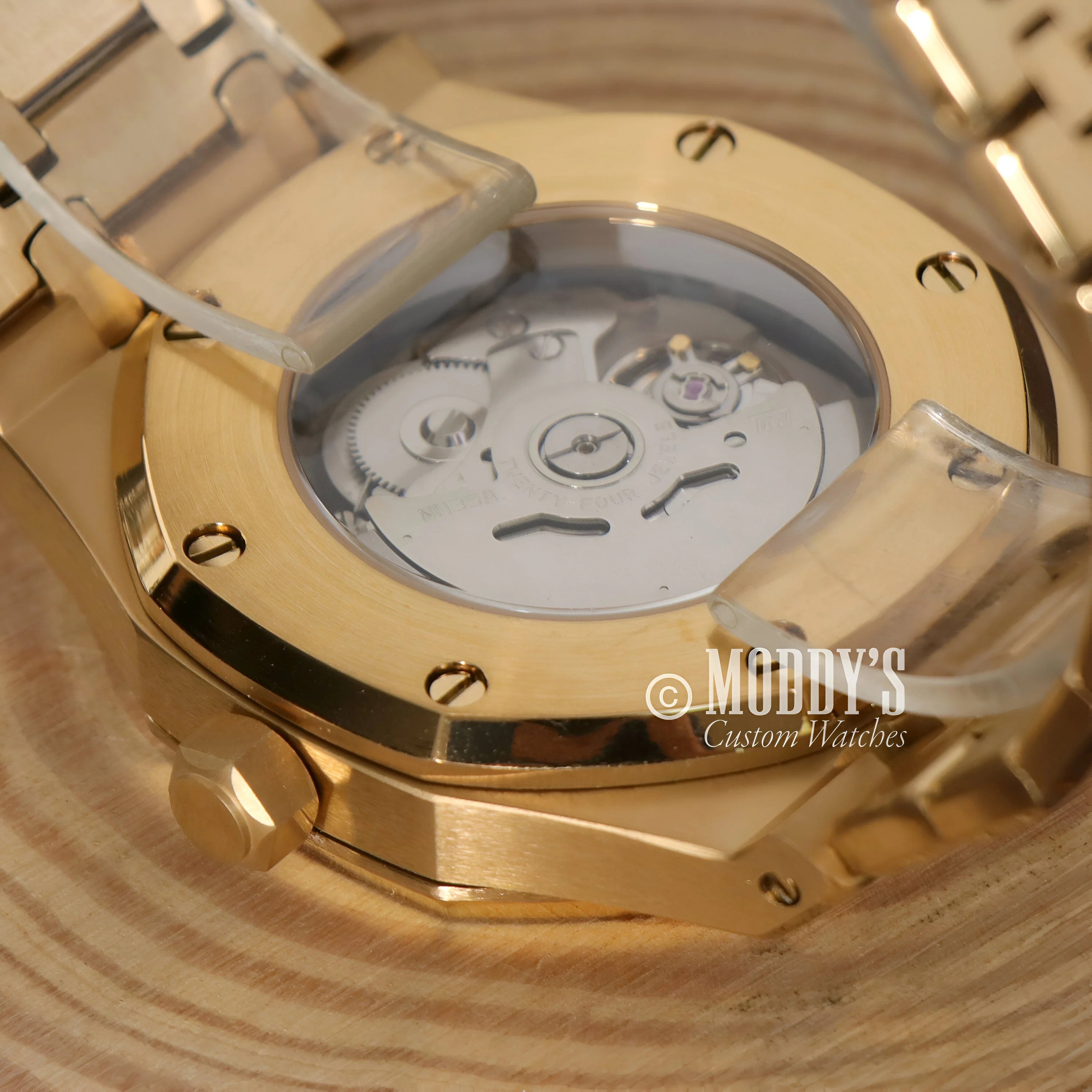 Gold-plated automatic watch movement in Royal Seikoak Black with transparent caseback