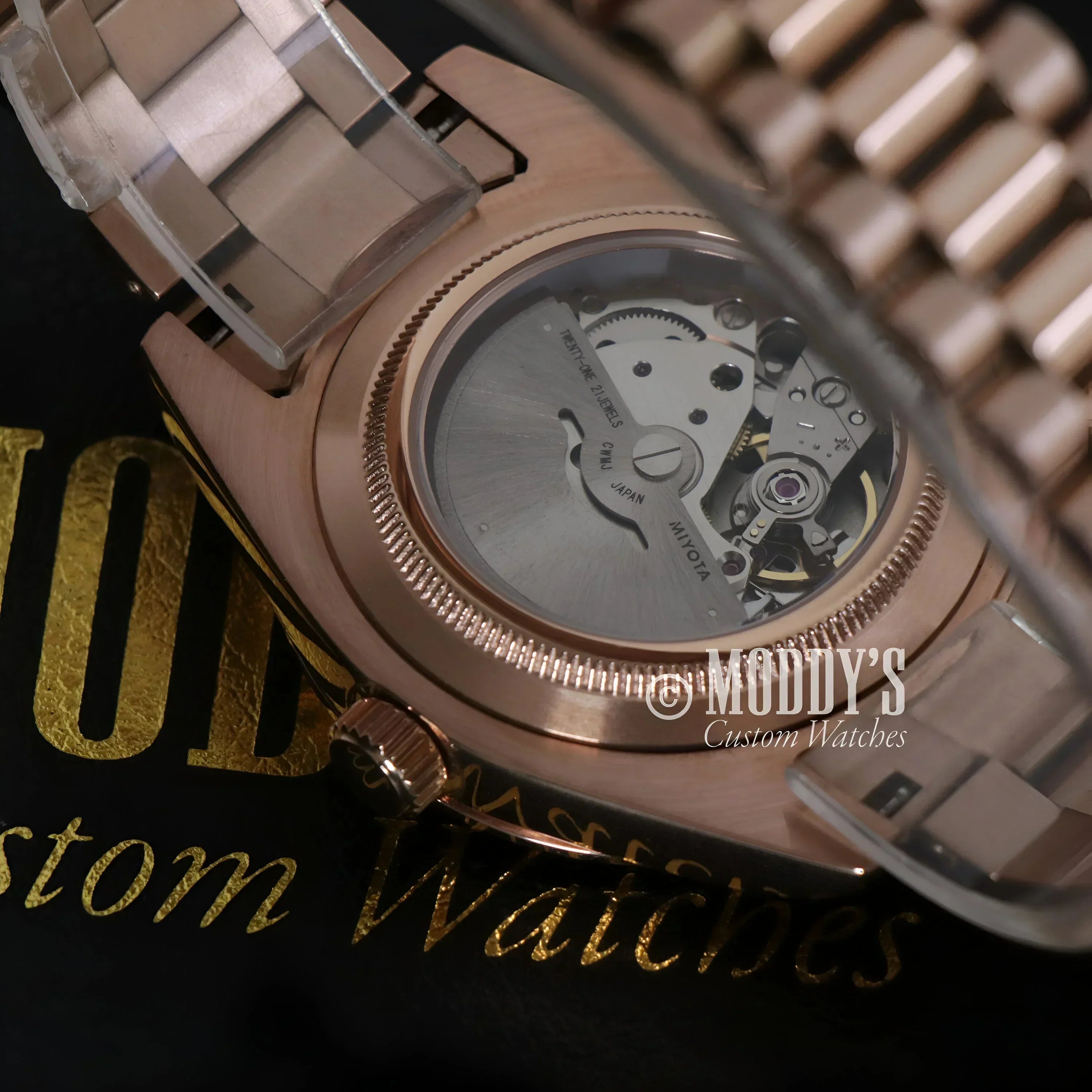 Rose gold wristwatch with exposed movement from Seikojust, featuring daydate rose gold design