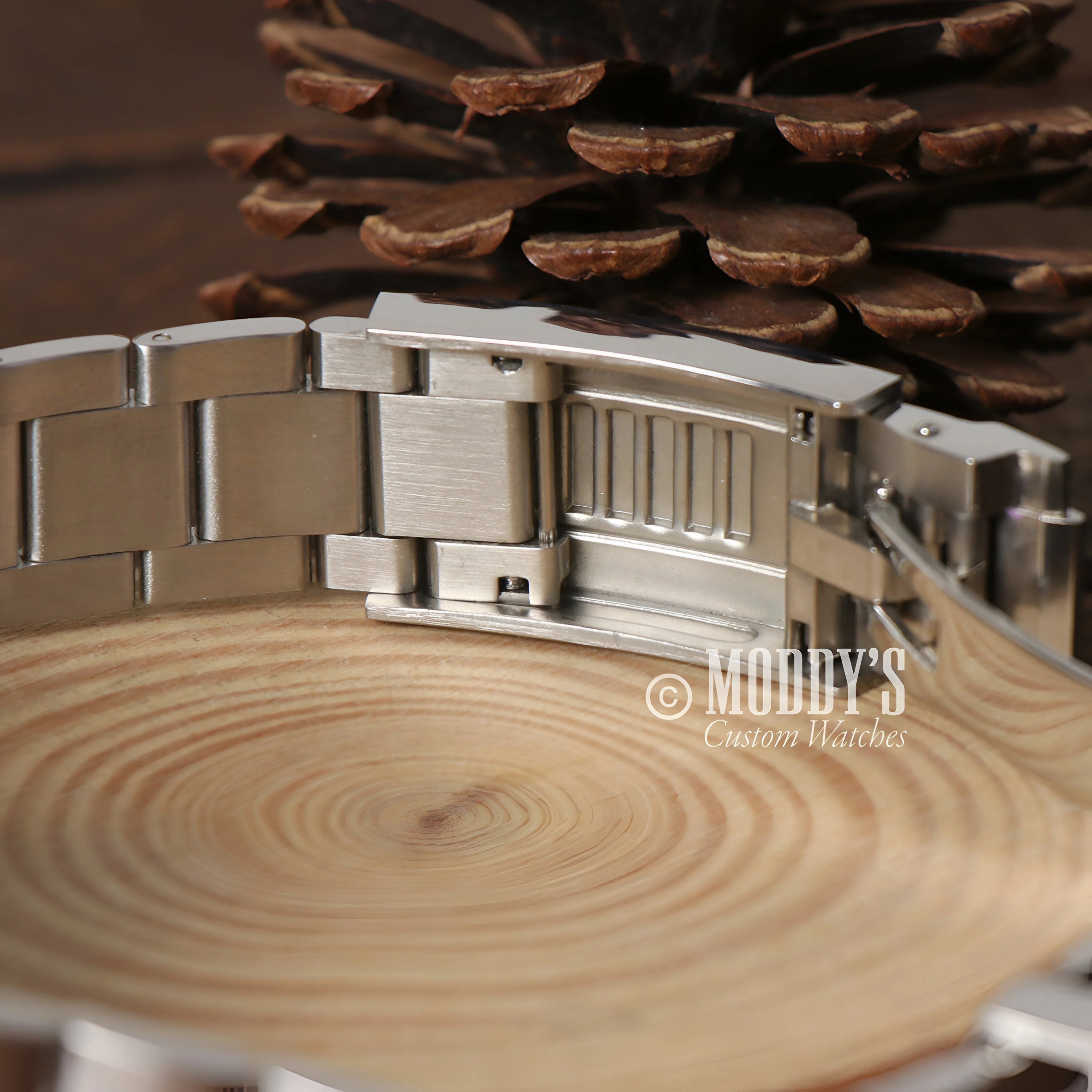 Seitona Rainbow: Metal Watch Bracelet On Wood Surface With Concentric Rings, Mod Daytona