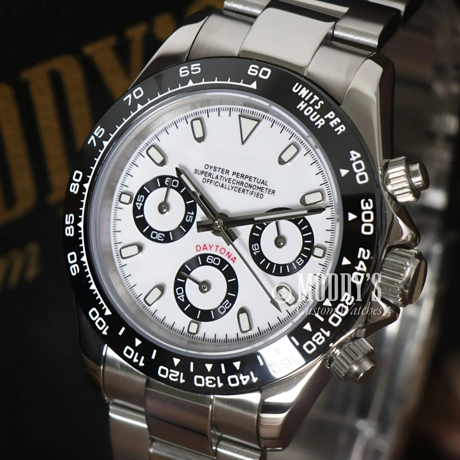 Silver Rolex Daytona watch with white face and black bezel, featuring Seiko VK63 hybrid movement