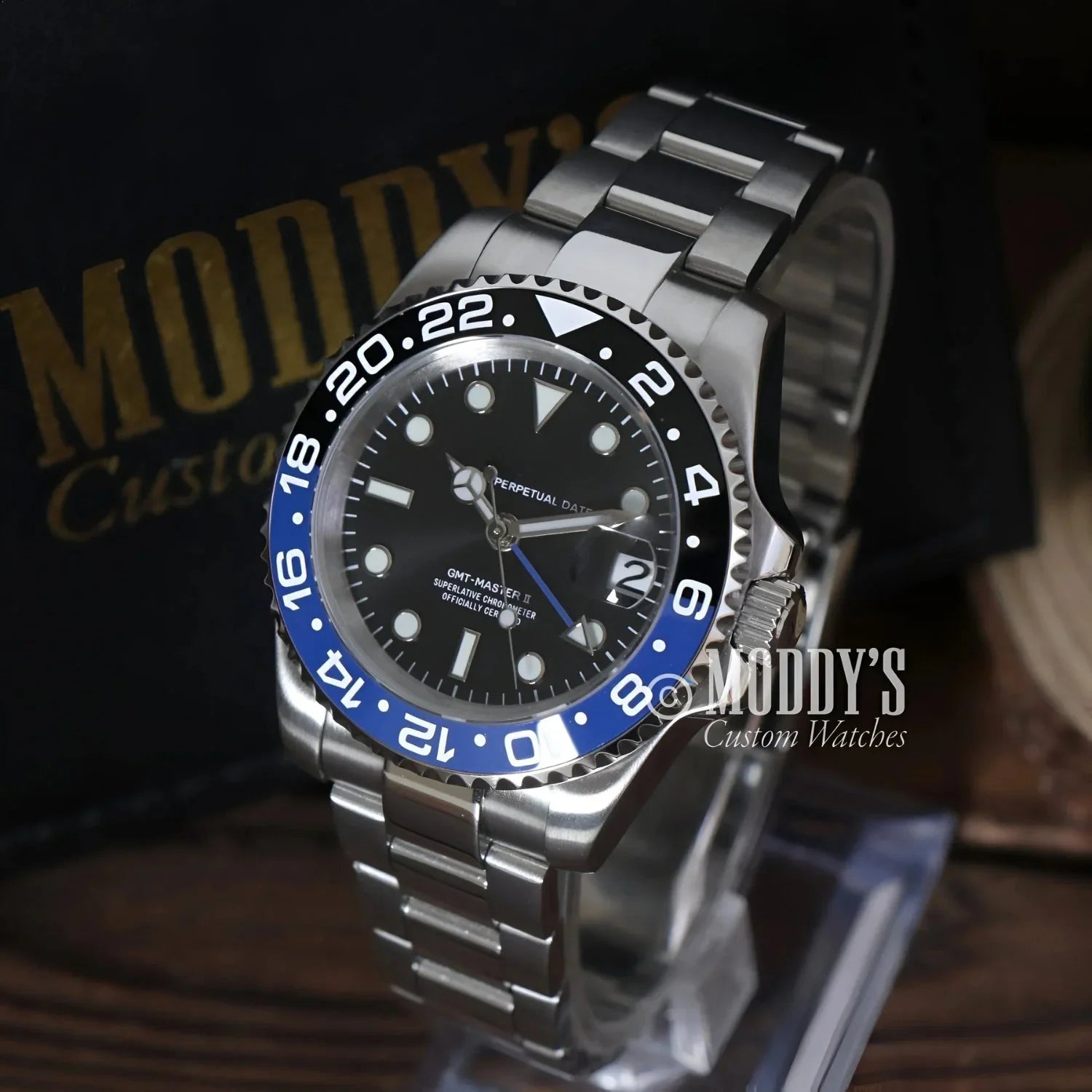 Silver wristwatch with blue and black bezel, featuring NH34 automatic movement, GMTeiko Batman