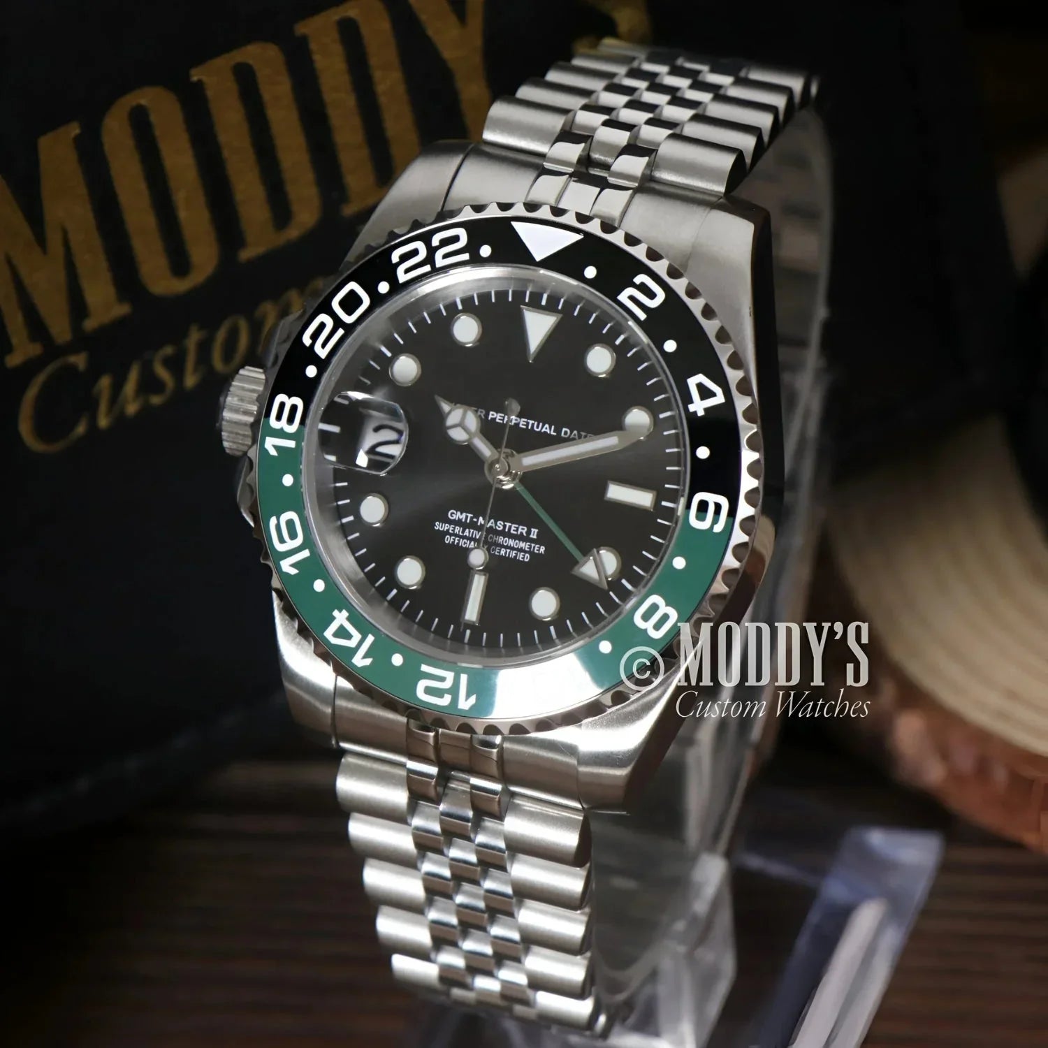 Silver wristwatch GMTeiko Sprite with black and green bezel, featuring Seiko NH34 movement