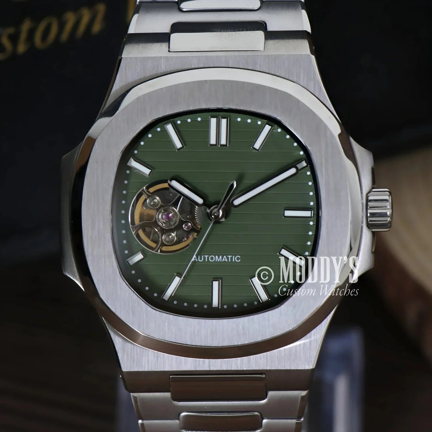 Silver wristwatch with green face featuring NH38 automatic movement in Nautiko design