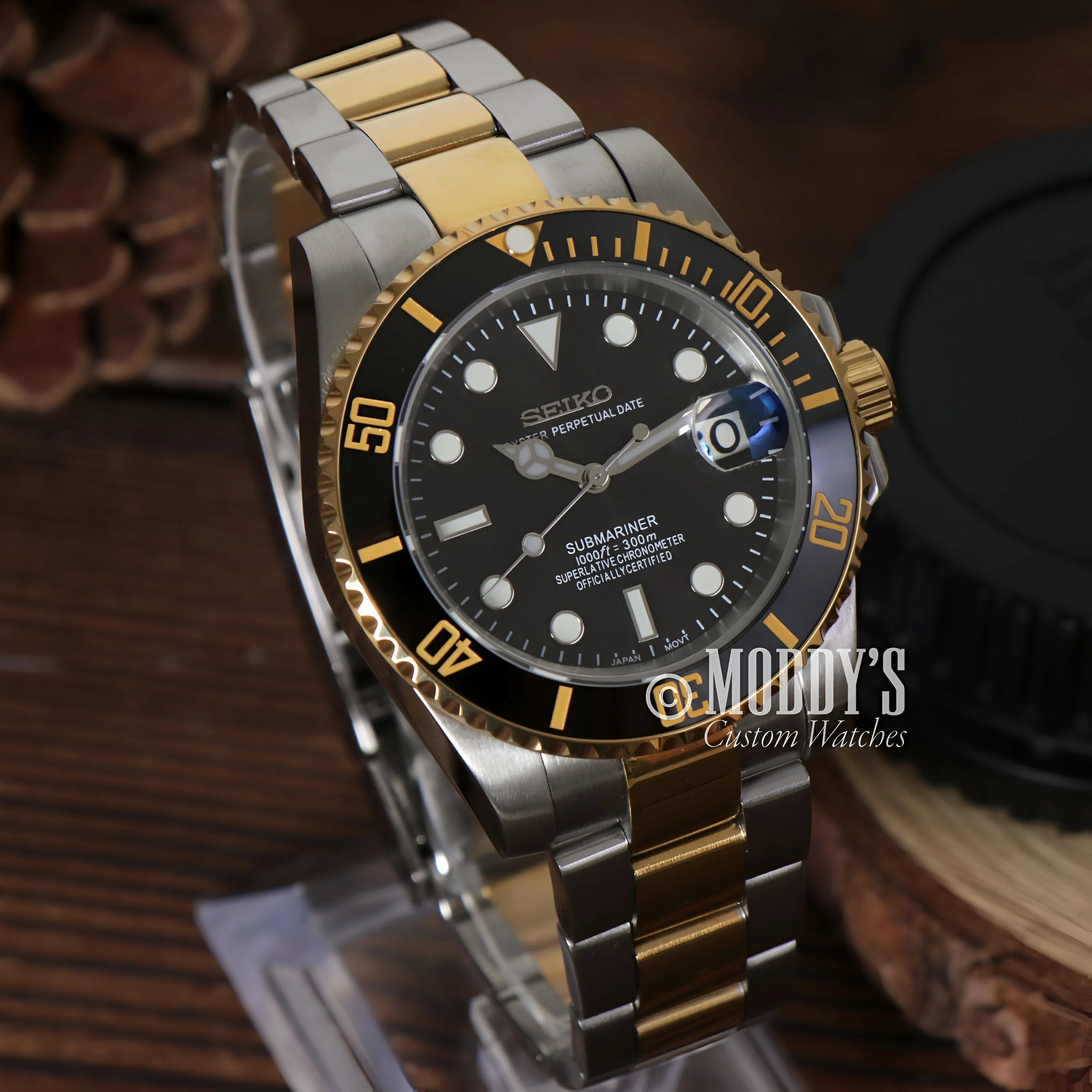 Two-tone Seikomariner Black wristwatch features black dial and gold accents, perfect for Seiko mod enthusiasts