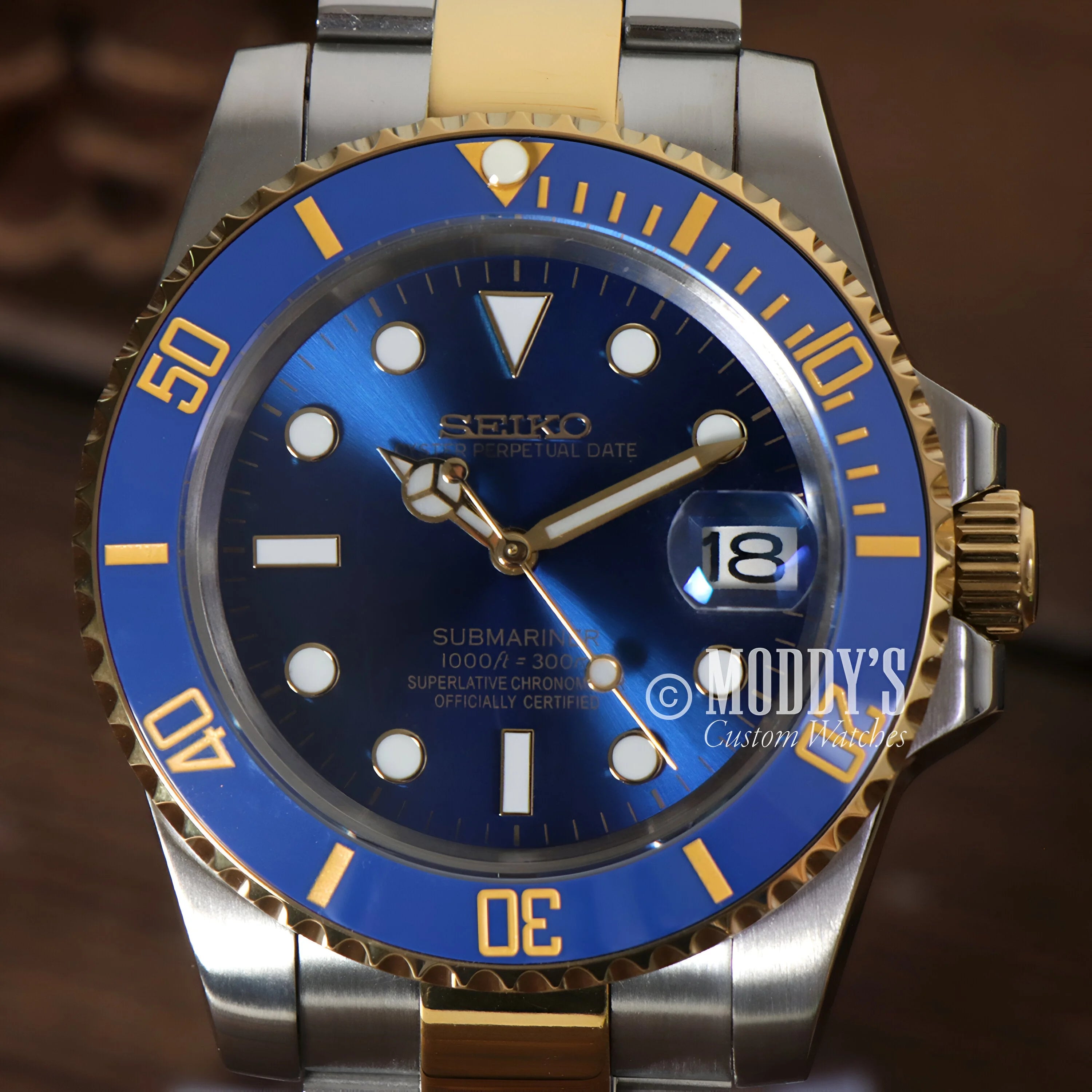 Seiko Mod Submariner watch with blue dial and gold accents on two-tone bracelet