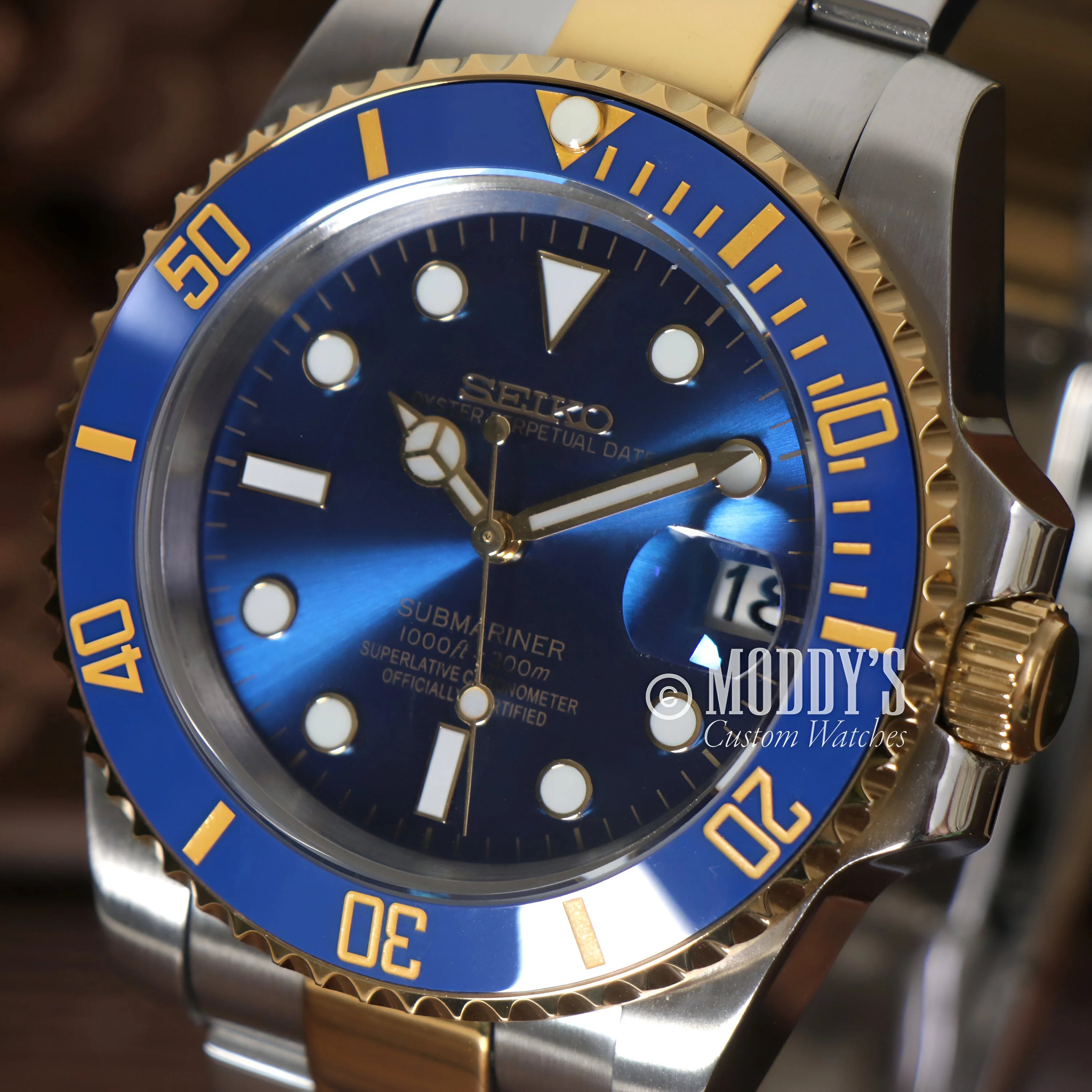 Luxury Seiko Mod Submariner Blue watch featuring a blue and gold bezel and dial