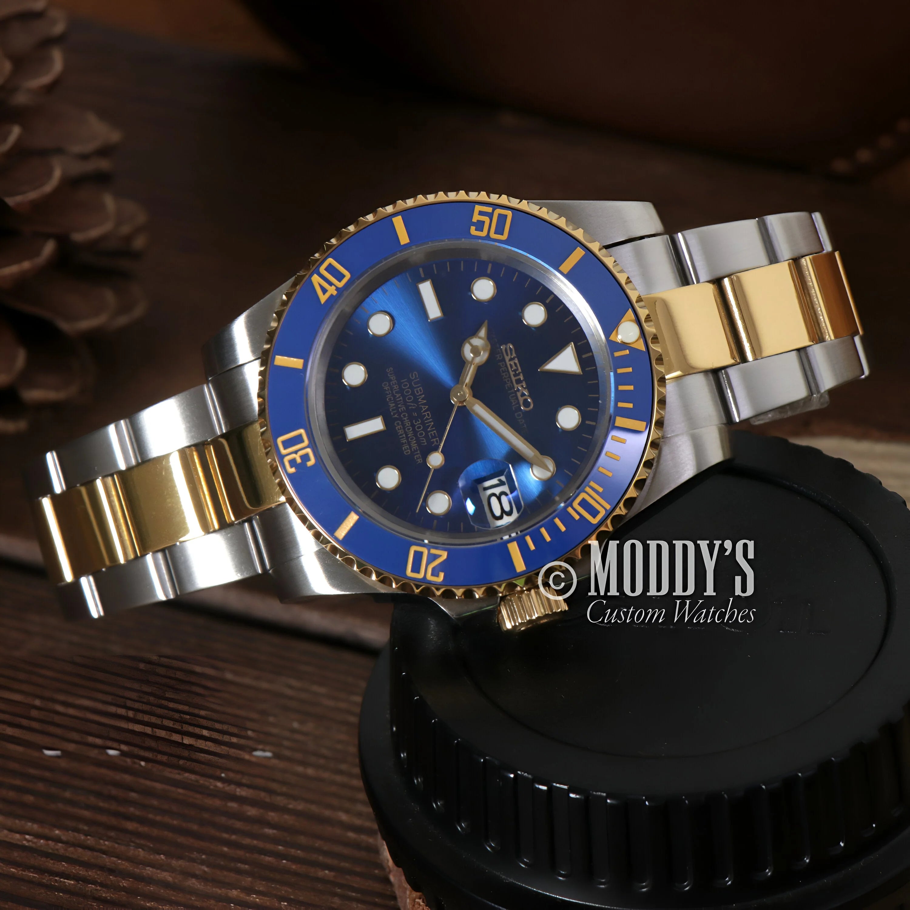 Luxury Seiko Mod Submariner with blue and gold bezel on two-tone metal bracelet