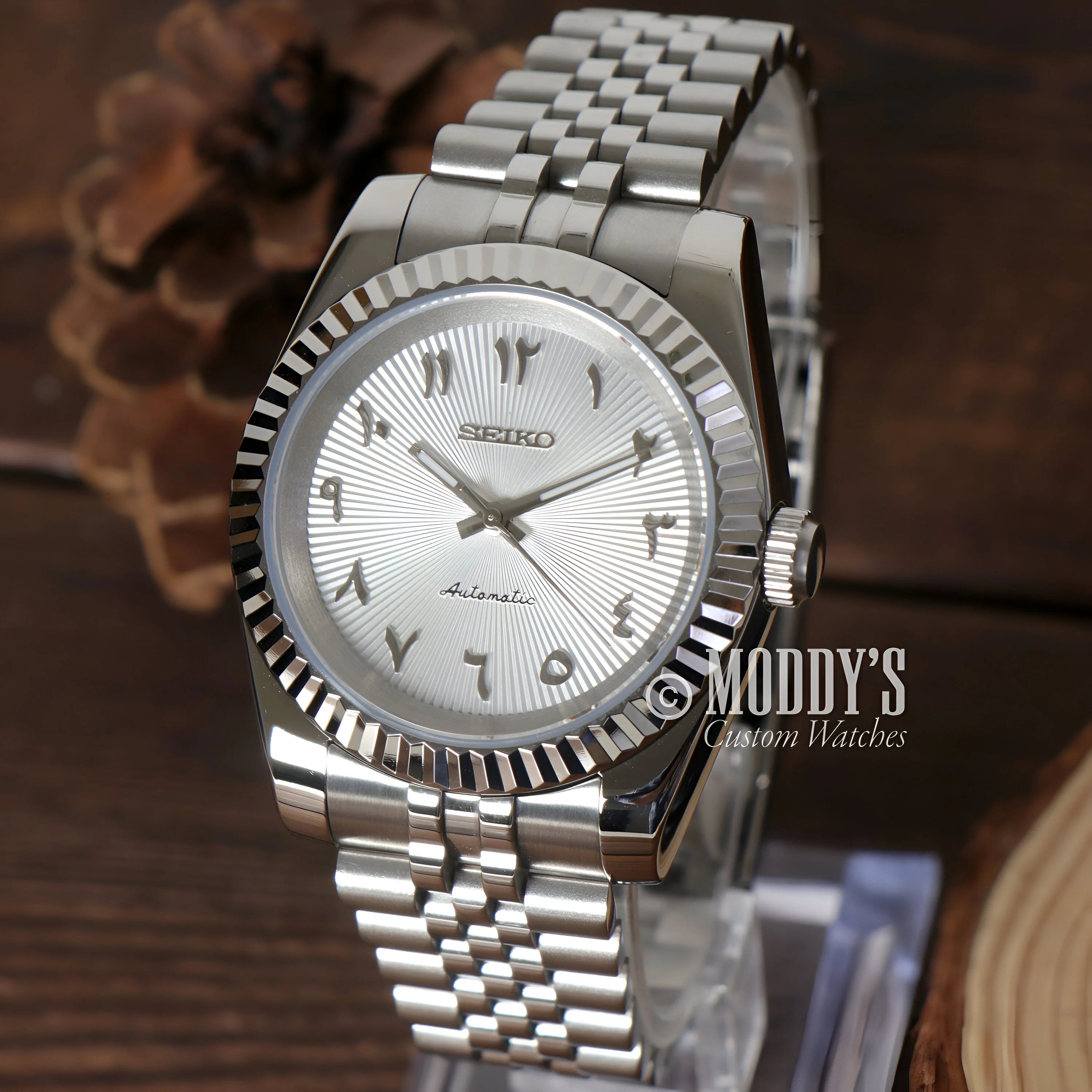 Silver Seiko wristwatch with fluted bezel and metal bracelet, featuring NH35 automatic movement