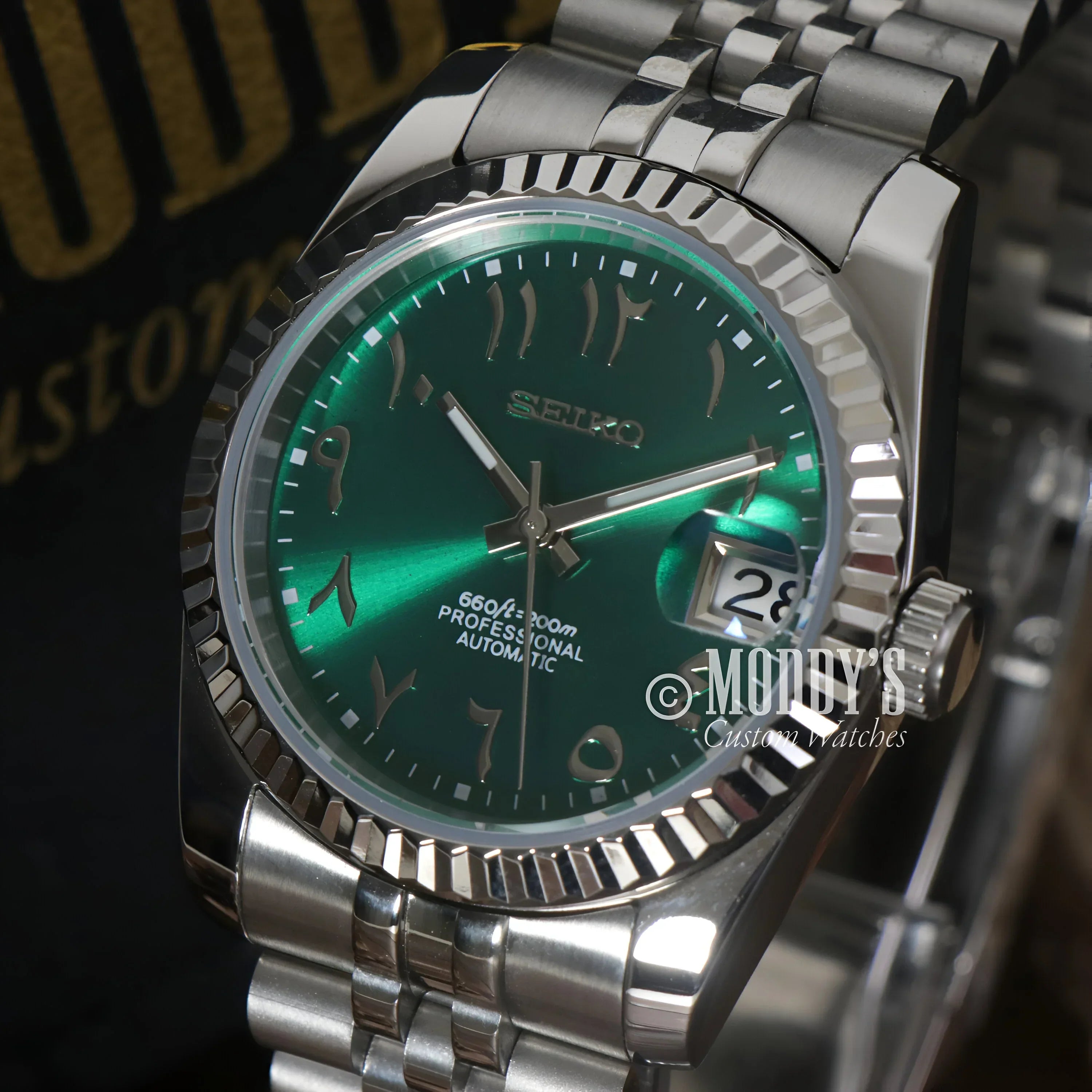 Green-faced Seiko wristwatch with Arabic numerals, featuring NH35 automatic movement