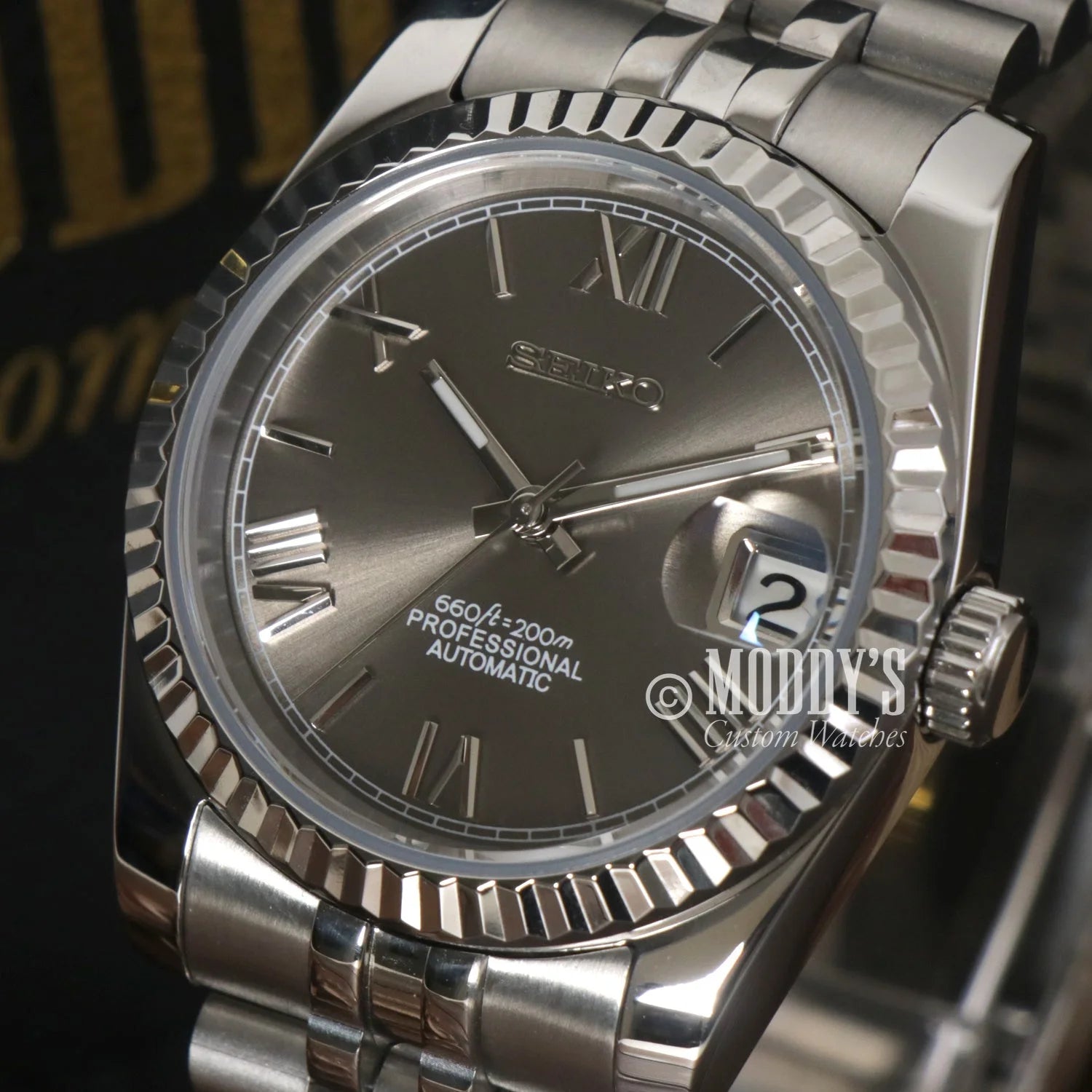 Stainless steel Rolex Datejust with fluted bezel and dark gray dial in Seikojust Roman Champagne