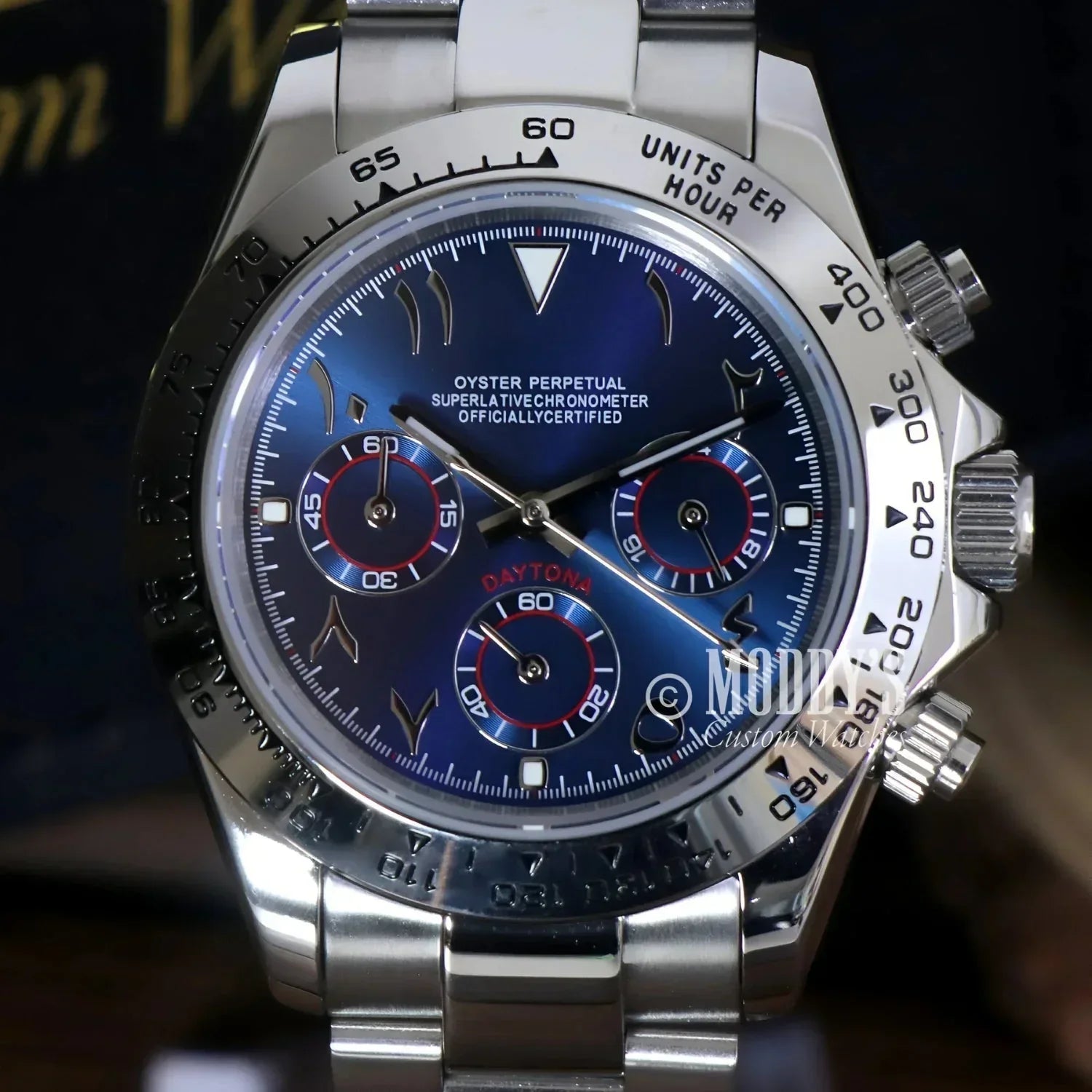 Silver Rolex Daytona watch with a blue face in Arabic Royal Blue style, featuring VK63 hybrid movement