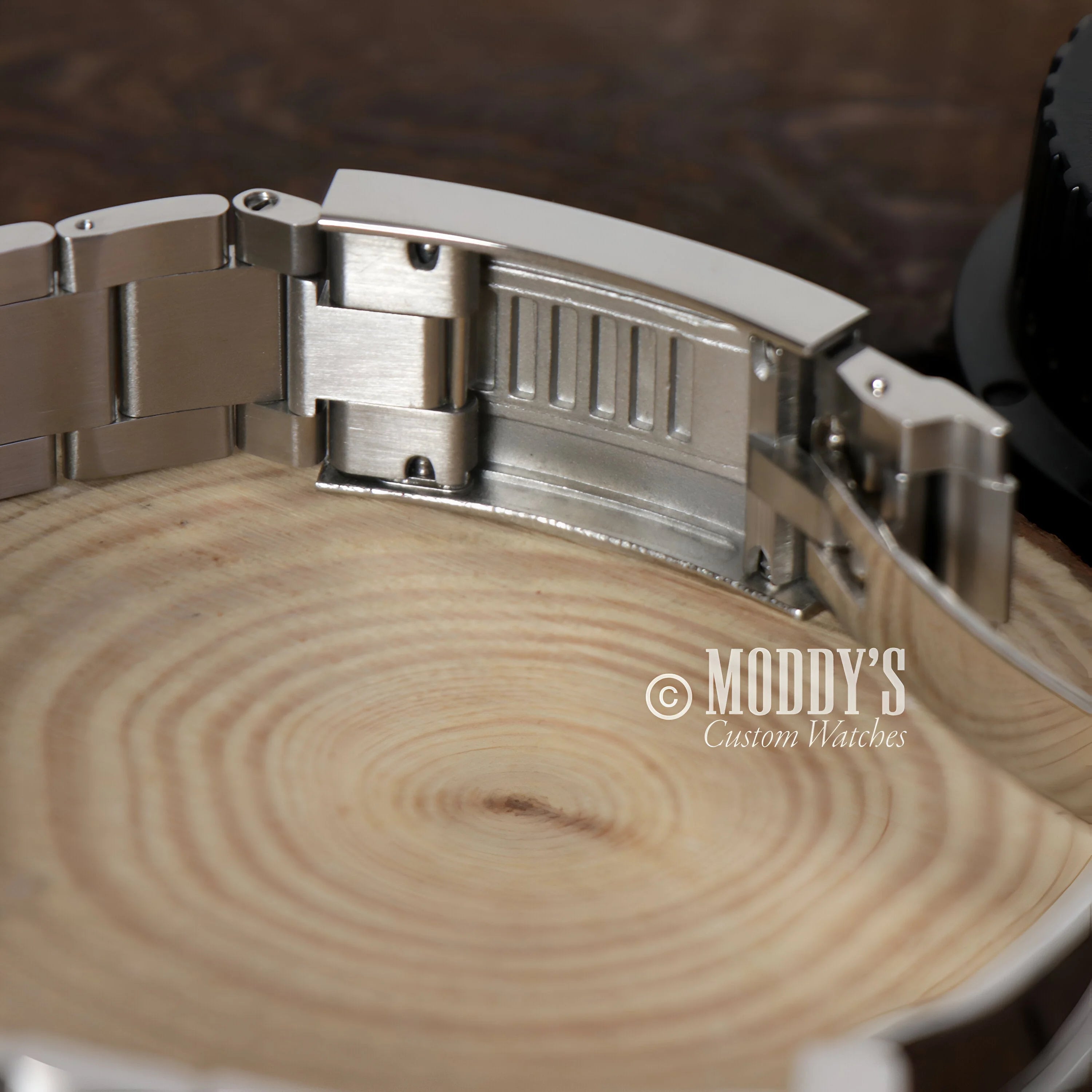 Metal watch bracelet for Seikomariner Hulk resting on a wooden surface