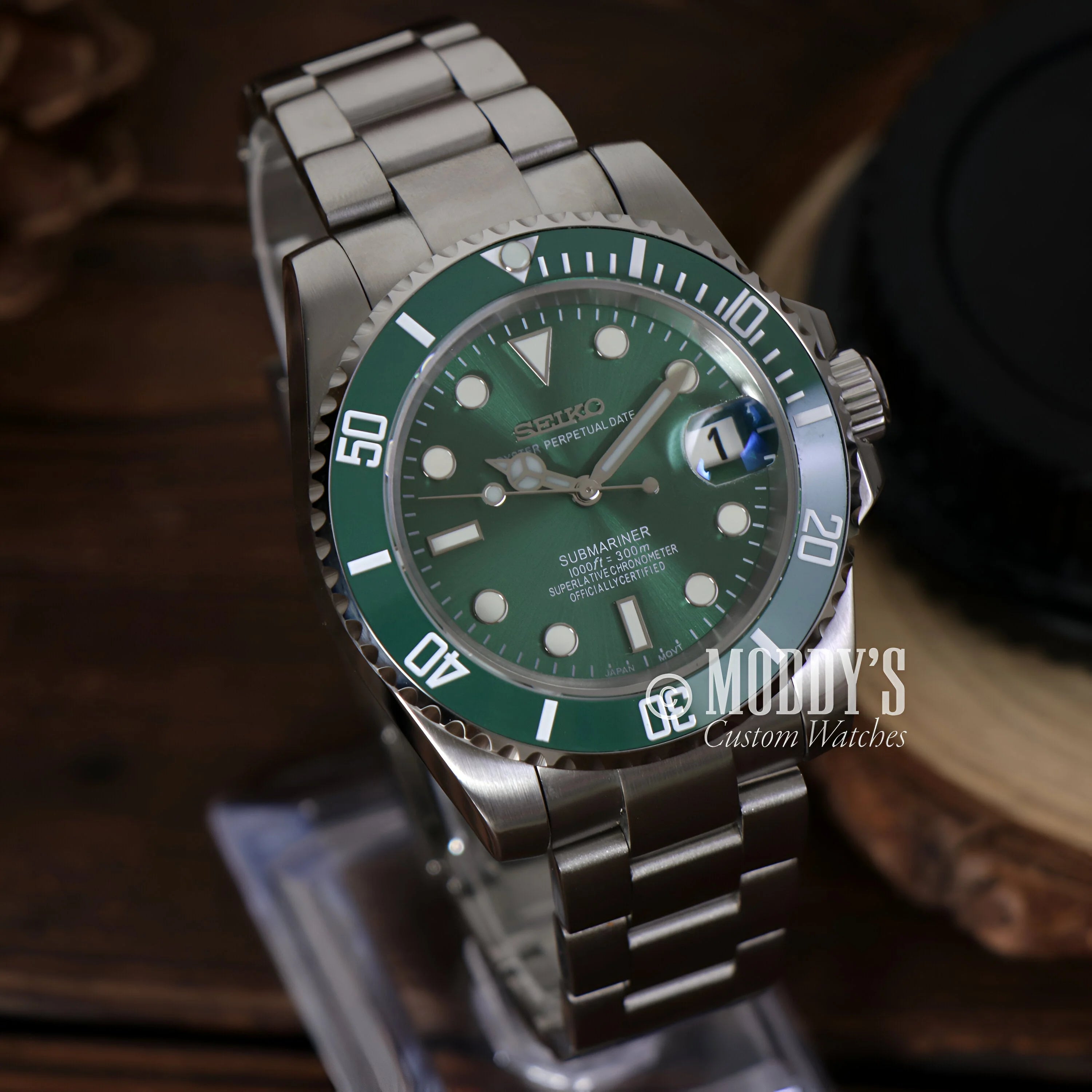 Rolex Submariner watch with green dial and bezel on stainless steel bracelet